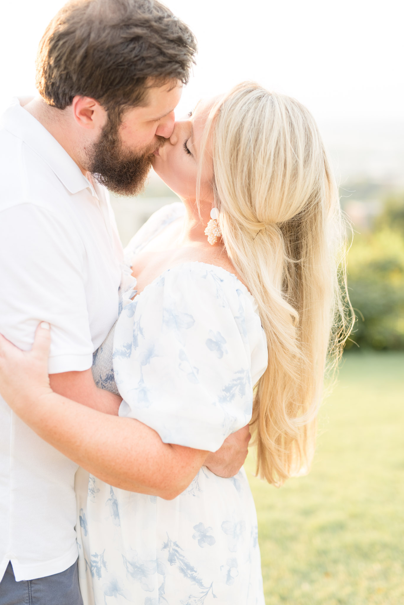 Husband and wife kiss at sunset.