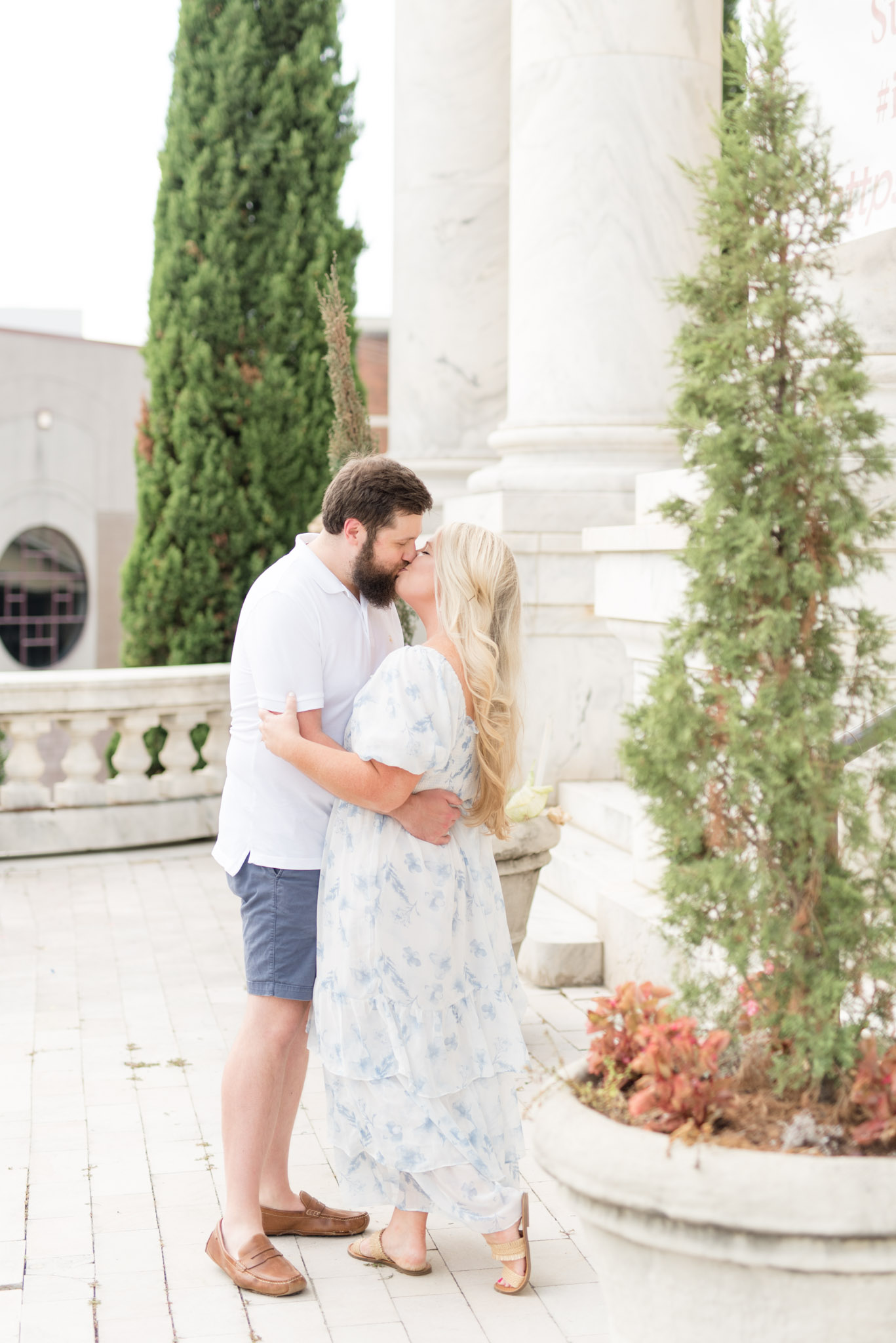 Married couple kiss on terrace.