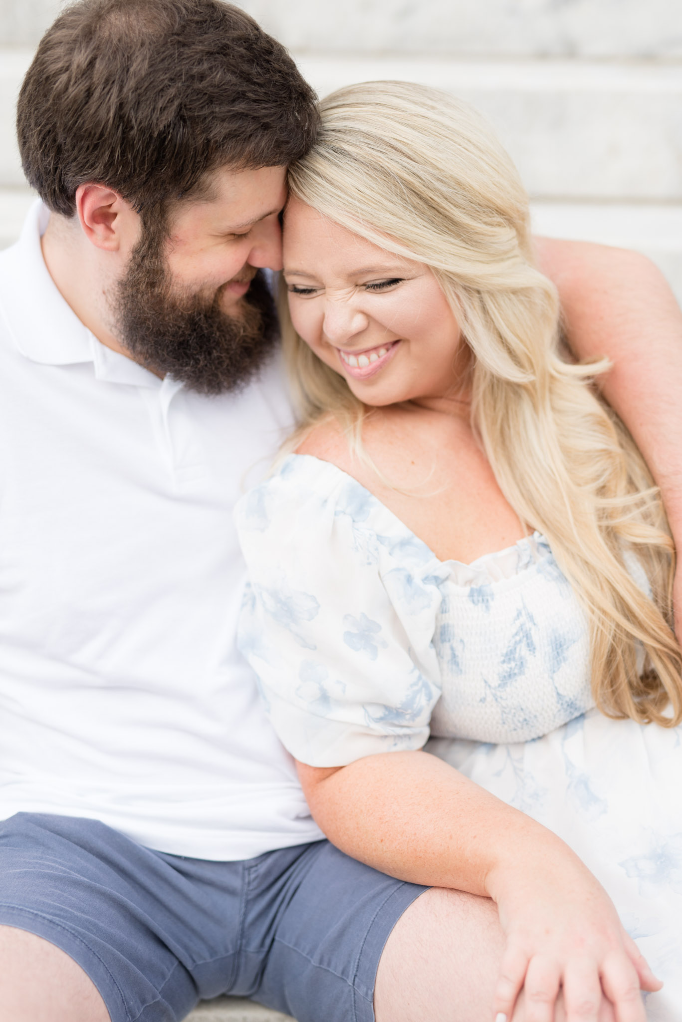 Couple laughs while snuggling on stairs