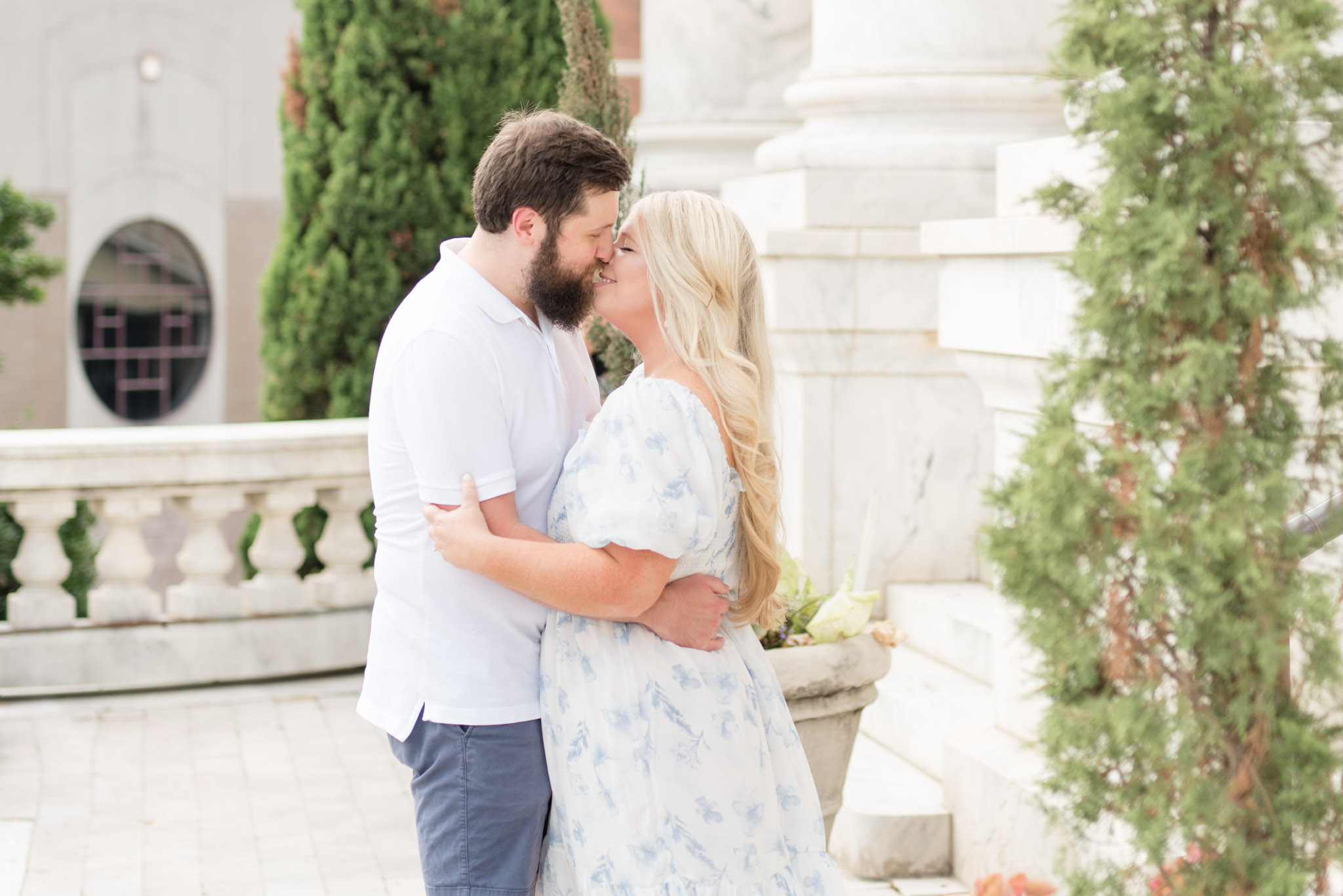 Husband and wife kiss on terrace.