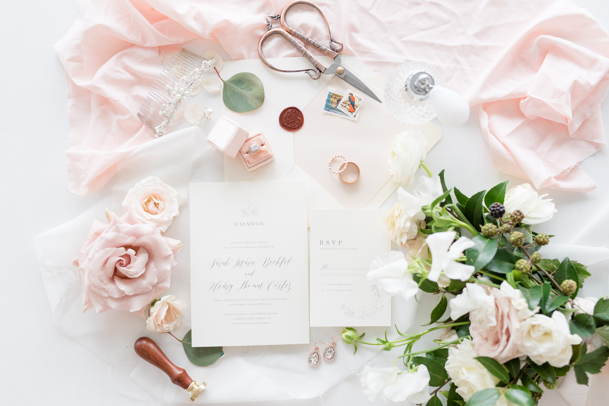 Wedding invitations sit with bridal details.