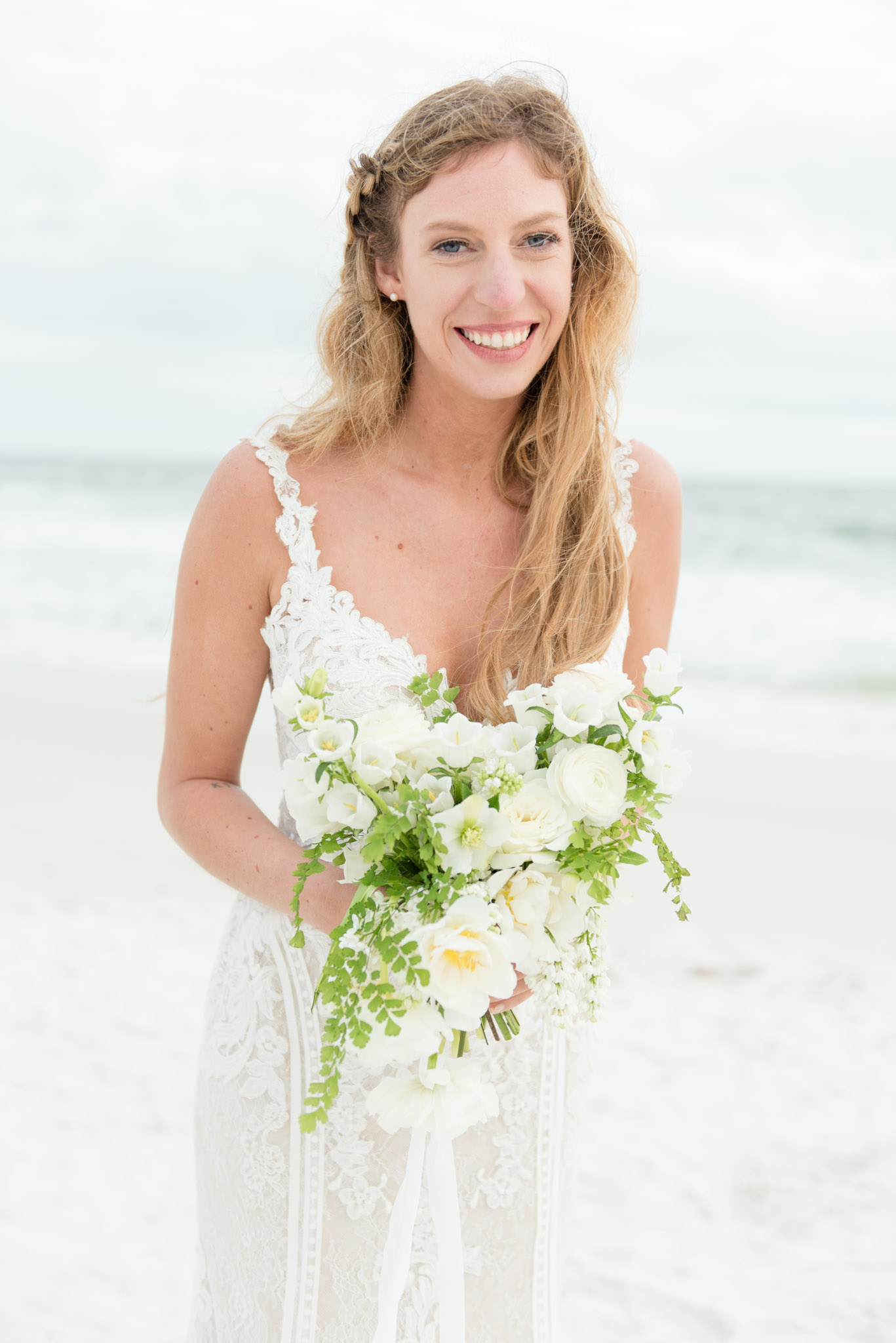 Bride smiles and laughs on beach.