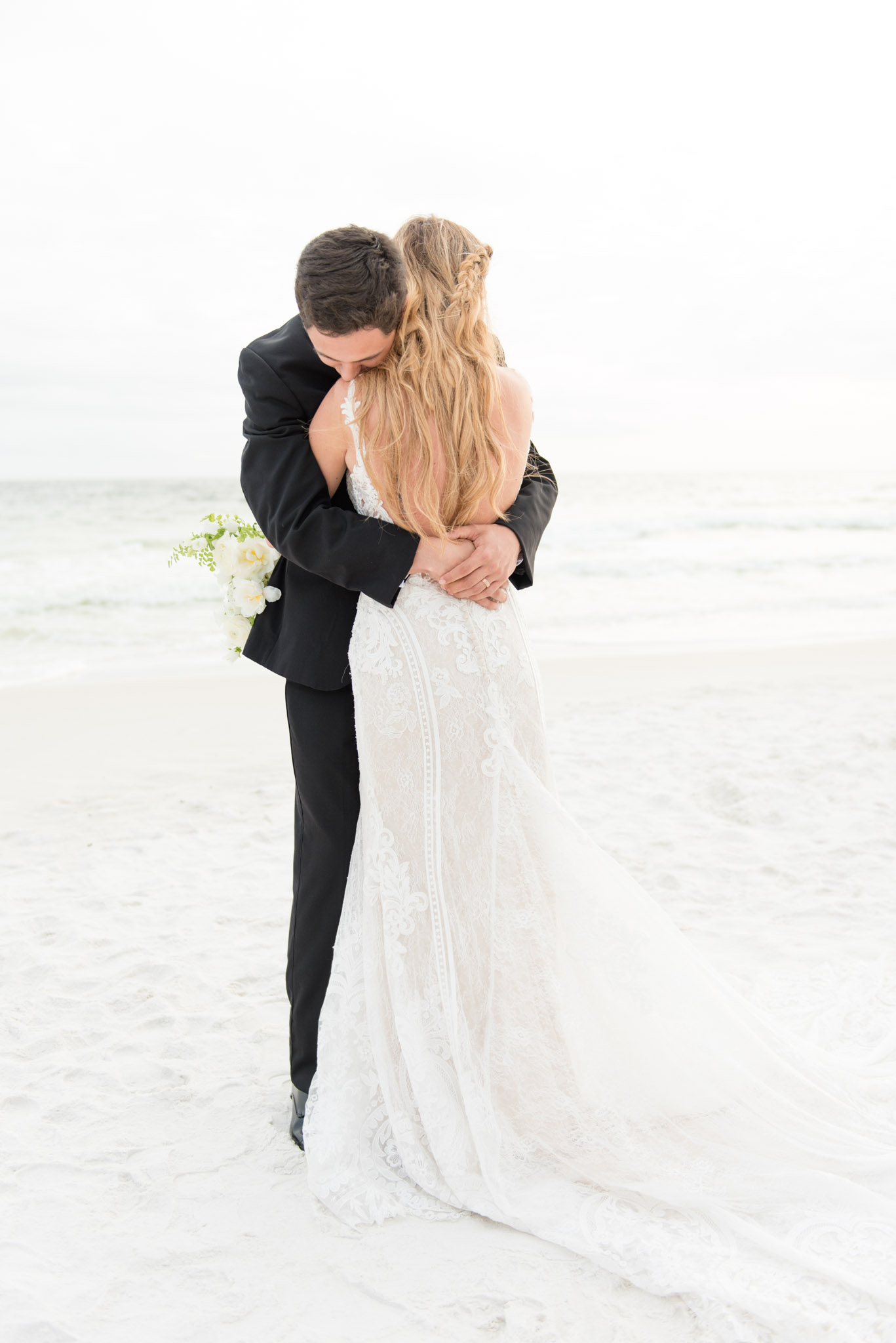 Groom hugs bride.