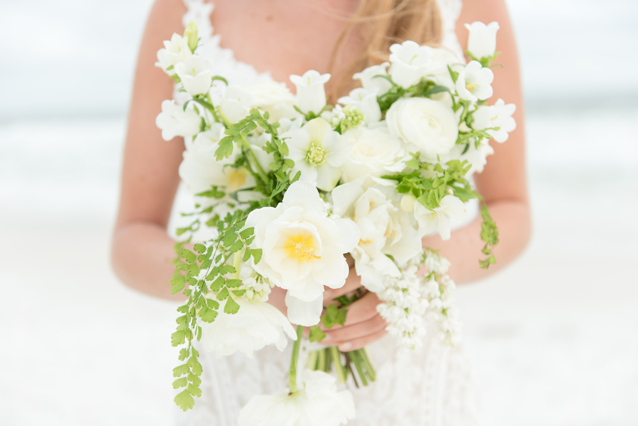 White bridal bouquet held by bride.