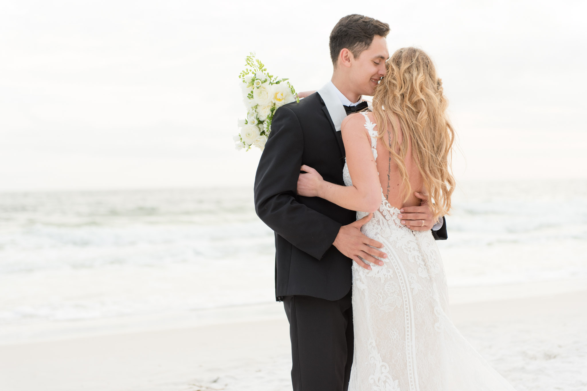 Groom laughs as he hugs bride.