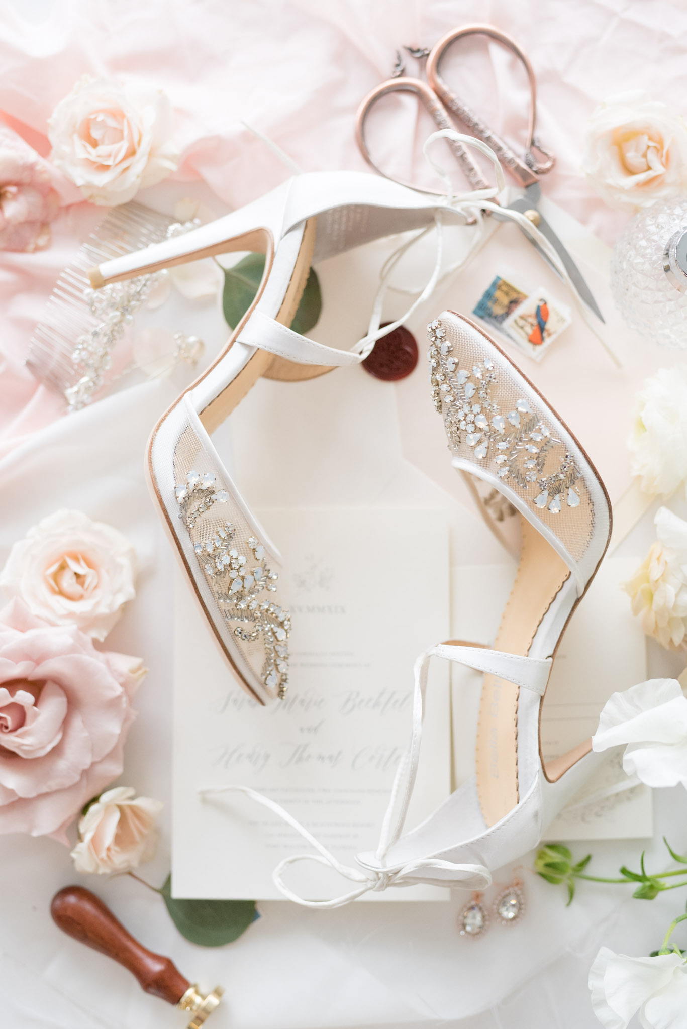 Wedding heels sit with wedding invitations.