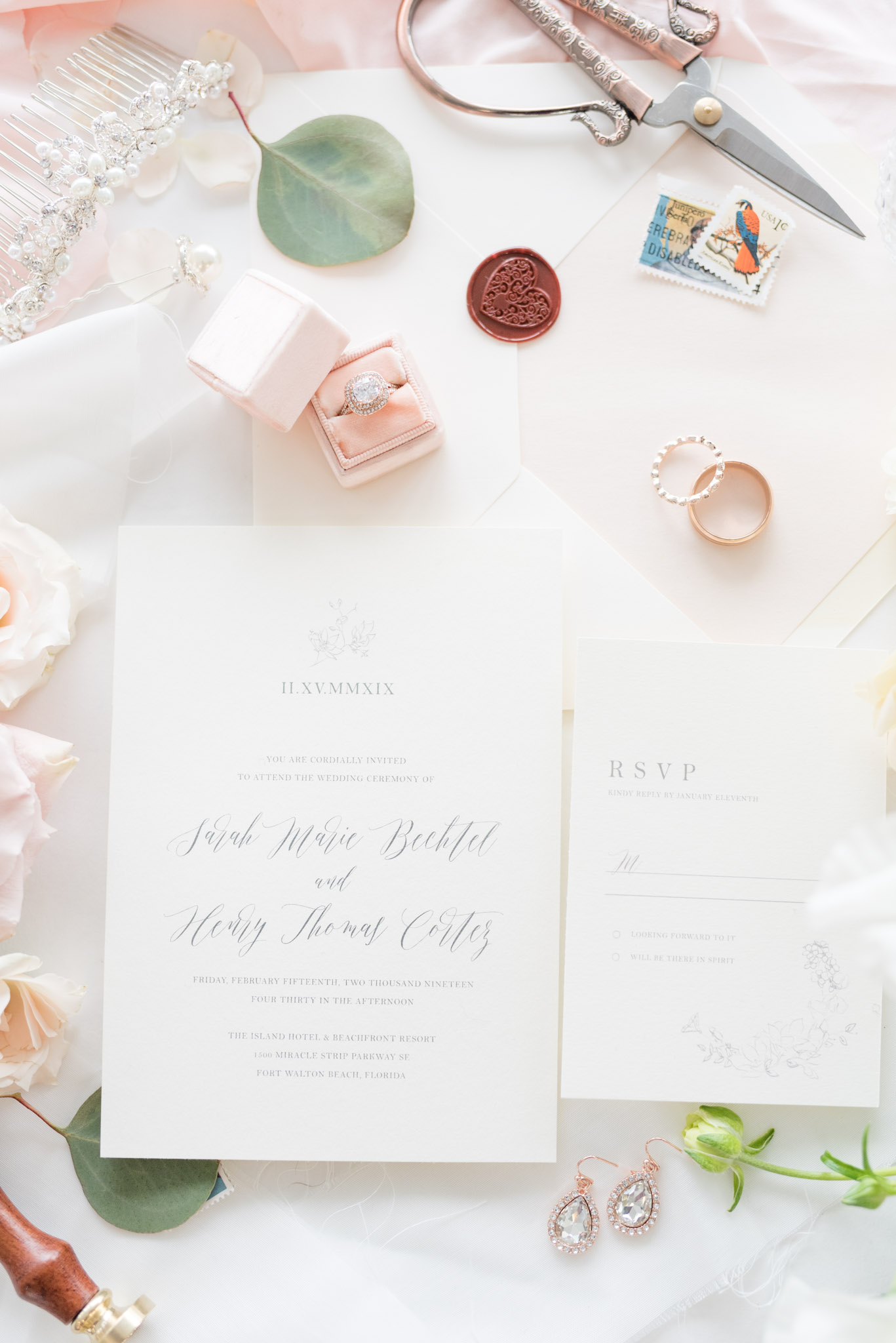 Wedding invitations sit with blush details.