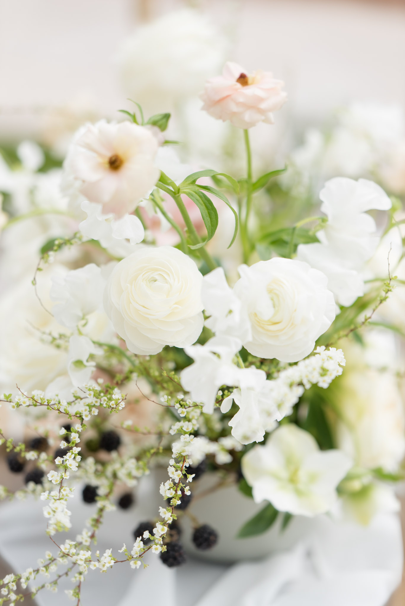 Floral arrangement with white and blush flowers.