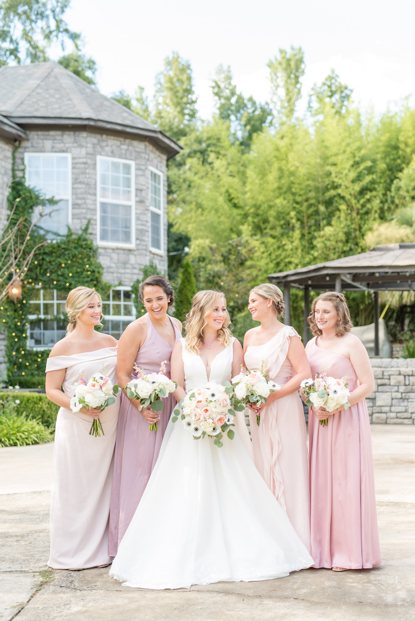 Bride and bridesmaids laugh together.