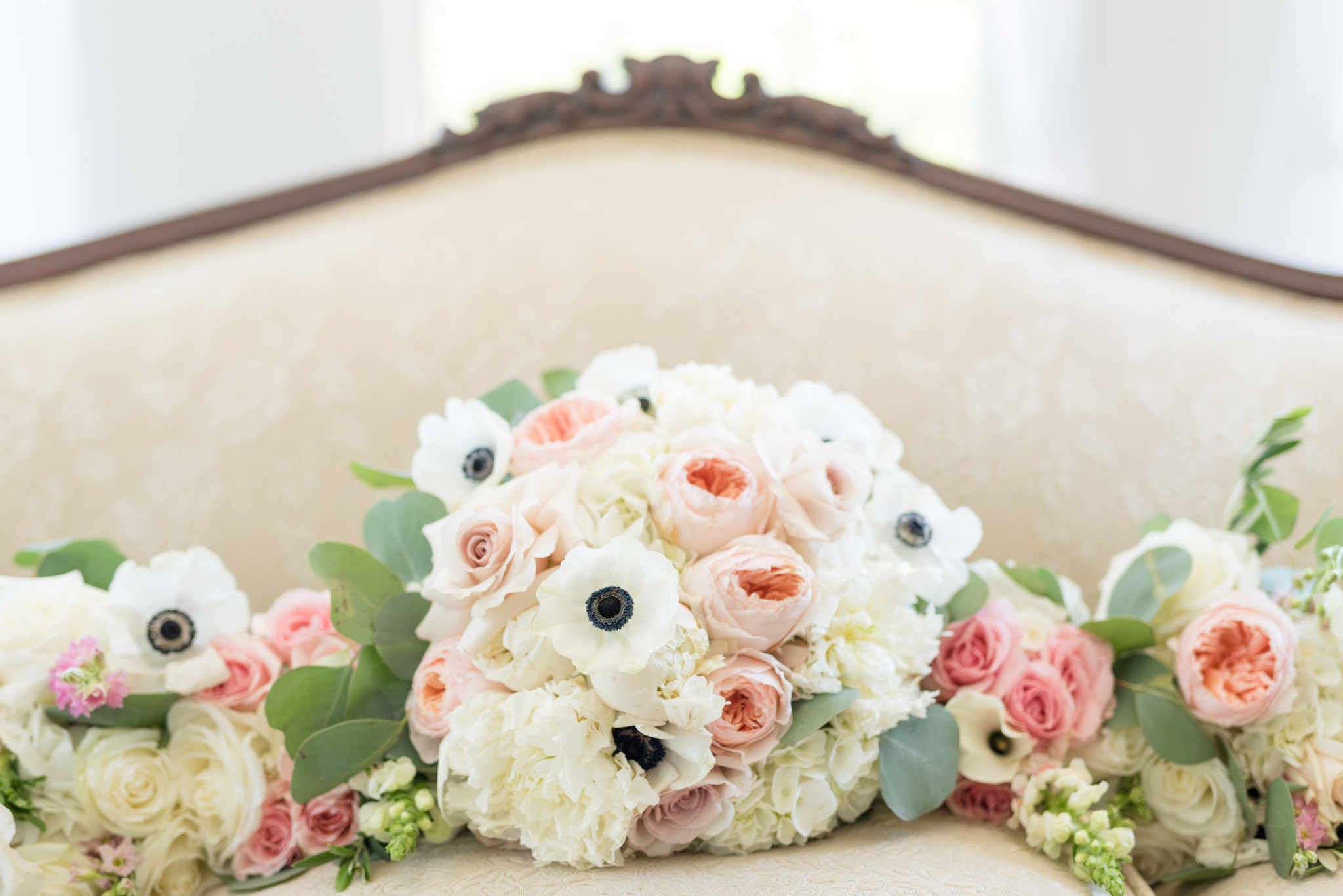 Wedding bouquets sit on couch.