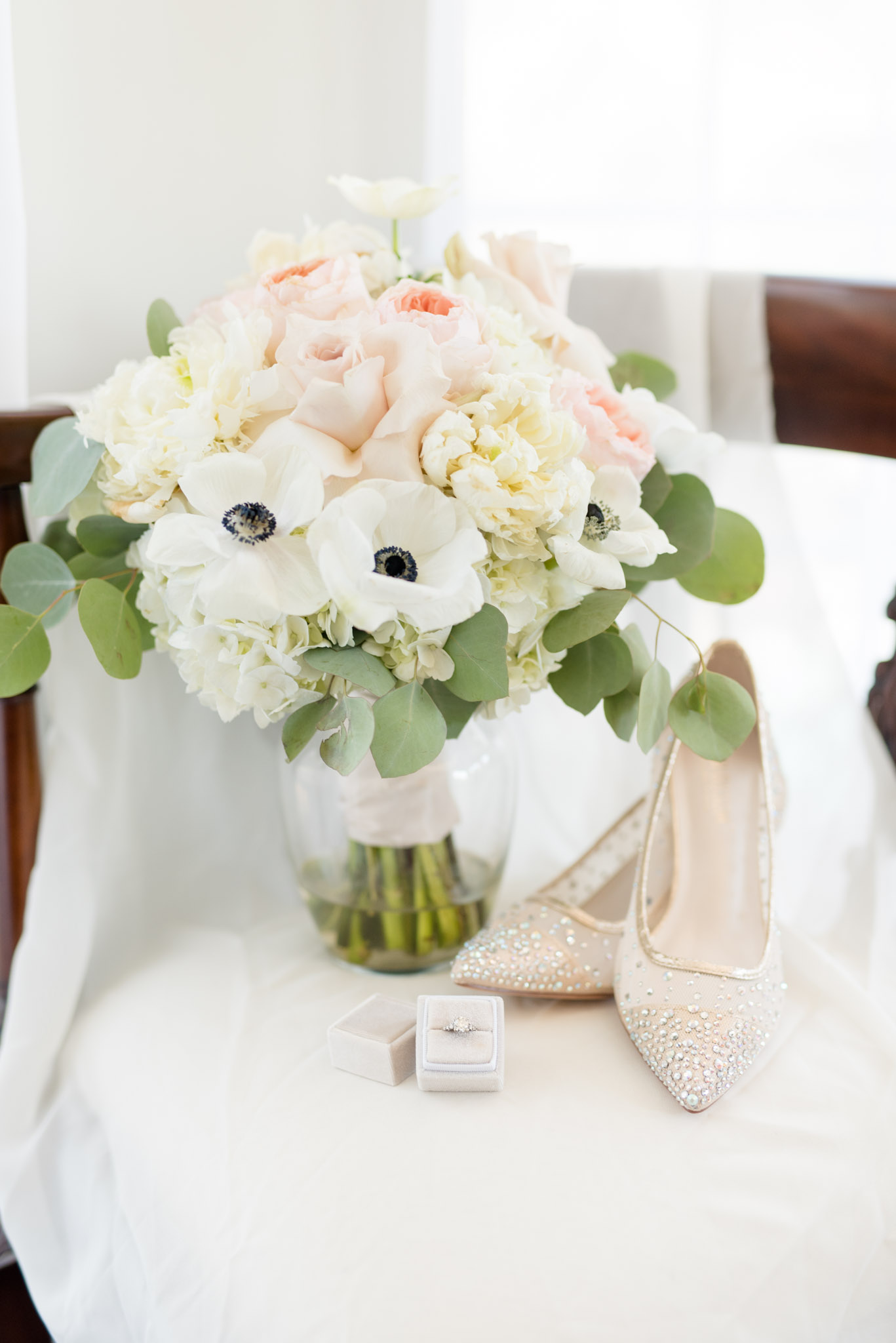 wedding bouquet sit on chair with shoes and ring.
