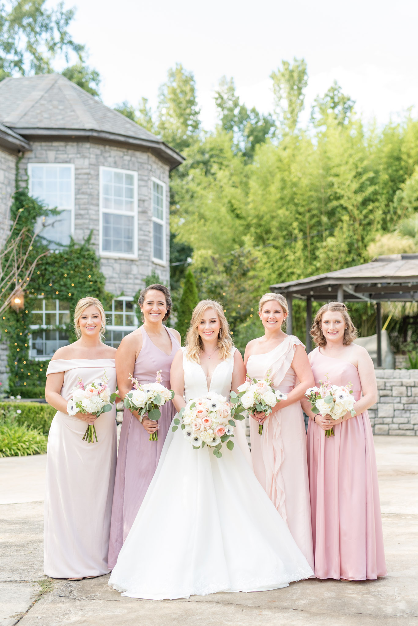 Bride and bridesmaids smile at camera.