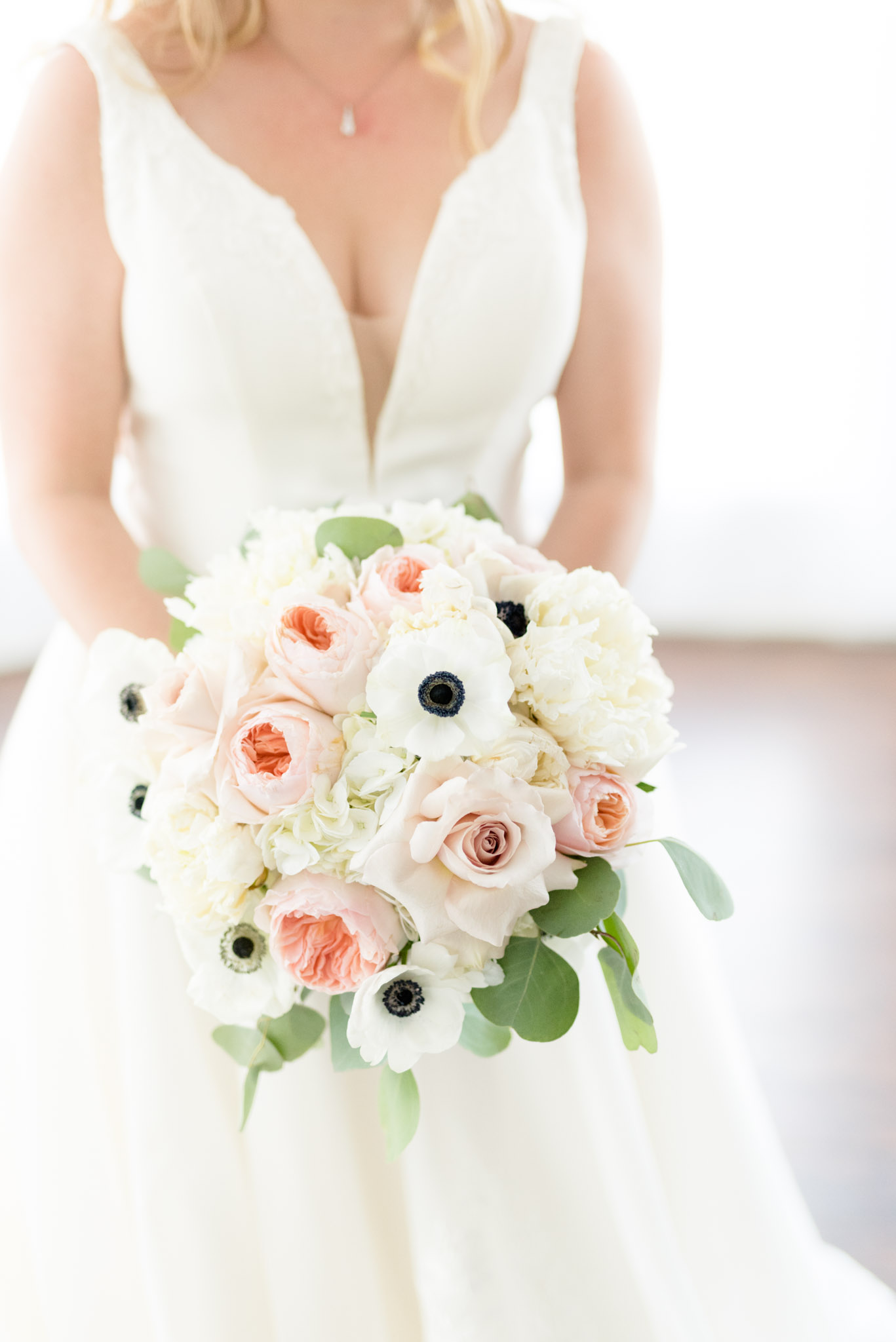 Bride holds pink and white wedding bouquet.