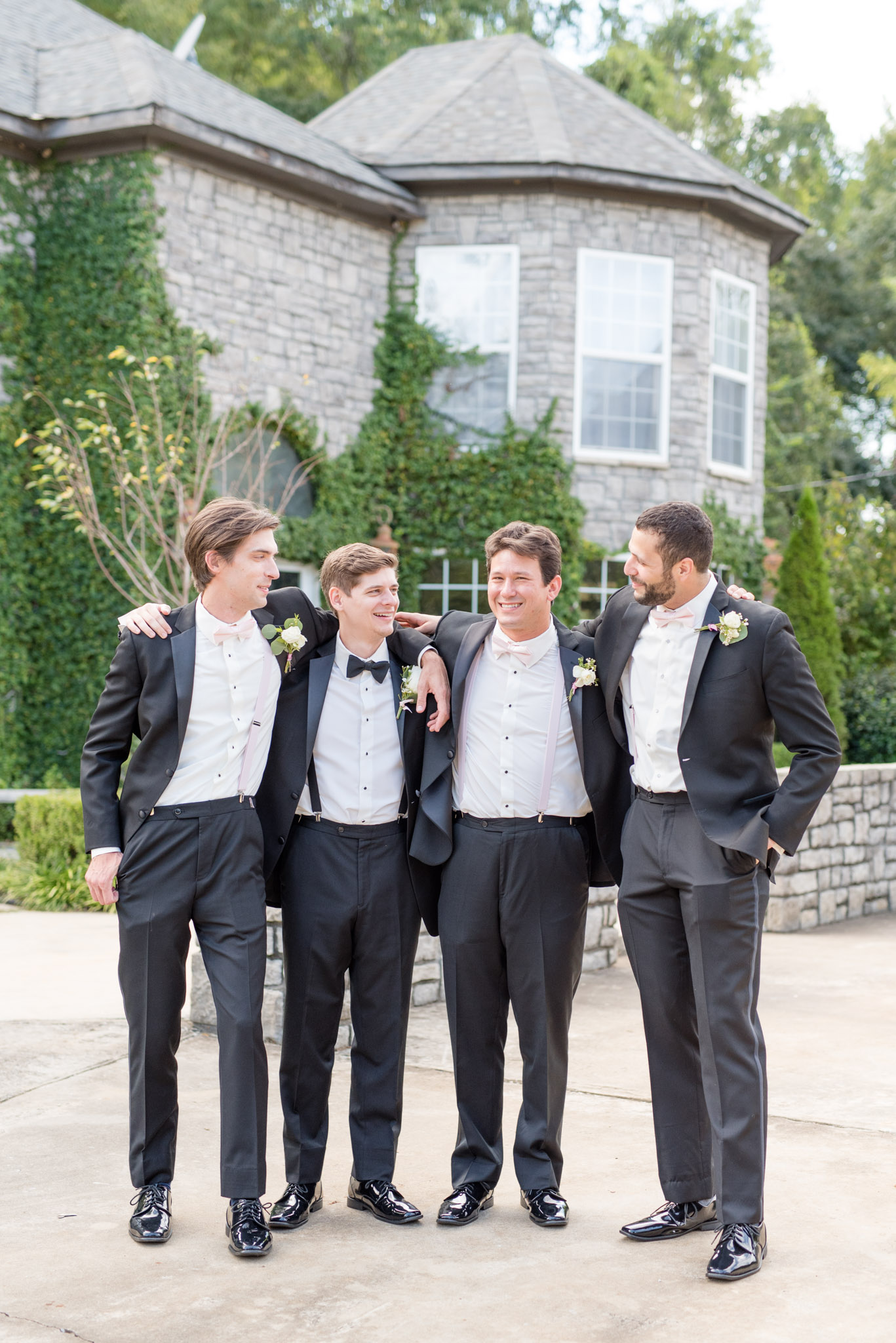 Groom and groomsmen laugh together.