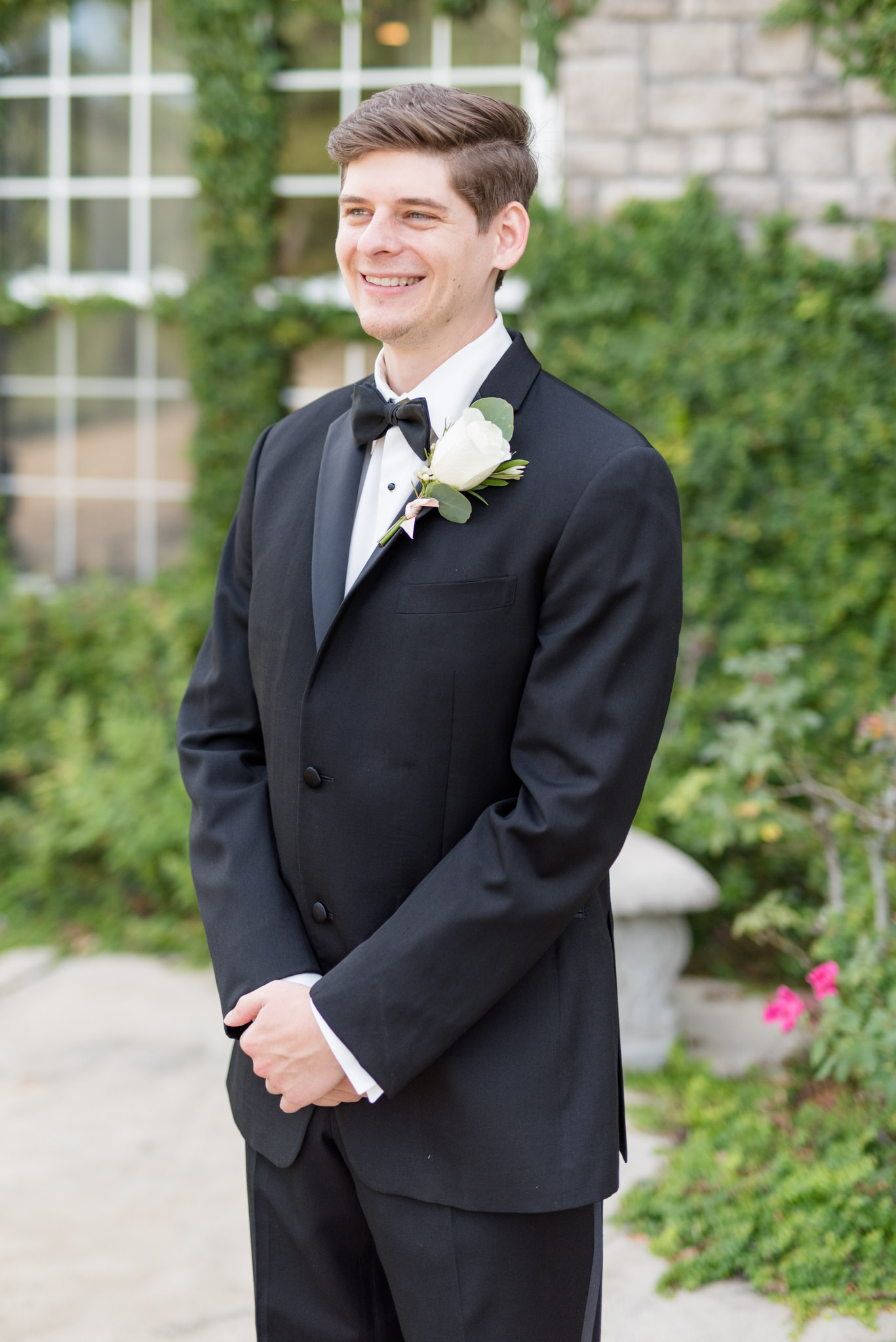 Groom smiles off camera.