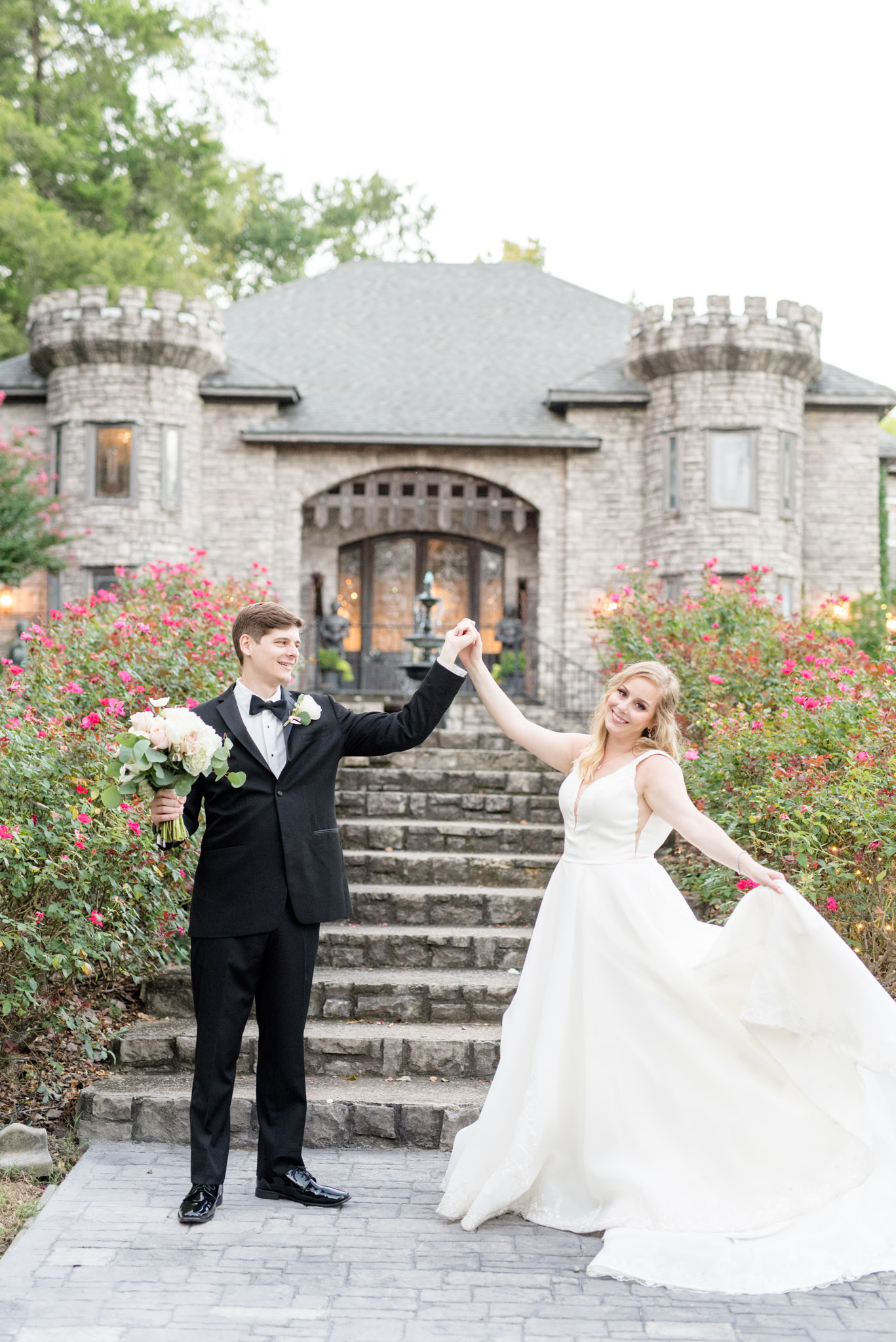 Groom twirls bride in front of Castle.