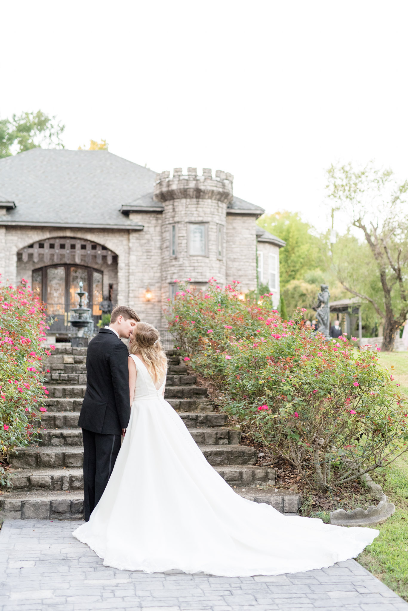 Bride and groom kiss near castle.