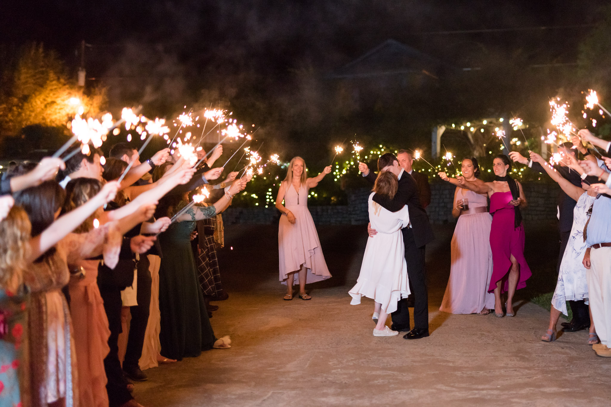 Bride and groom kiss during sparkler exit.