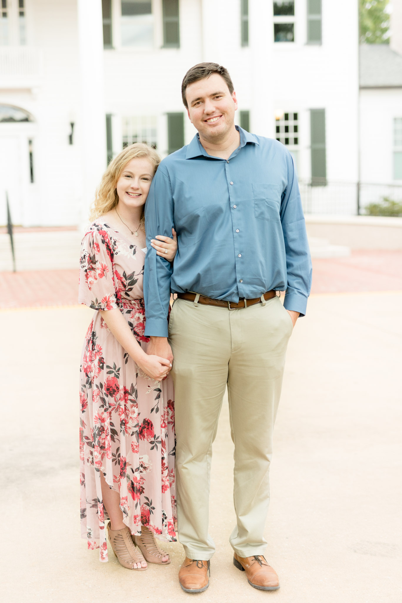 Engaged couple smiles at camera.