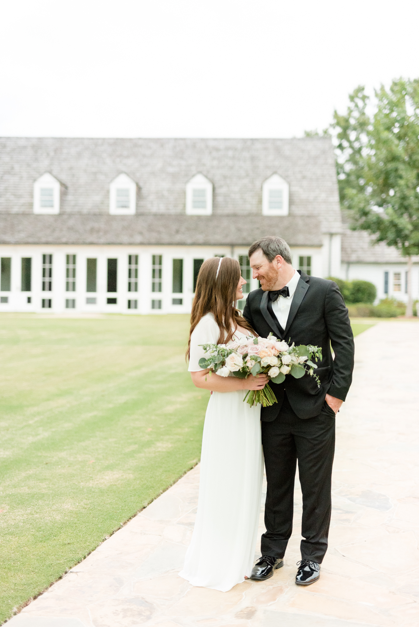 Couple Smiles in front of Hamilton Place at Pursell Farms