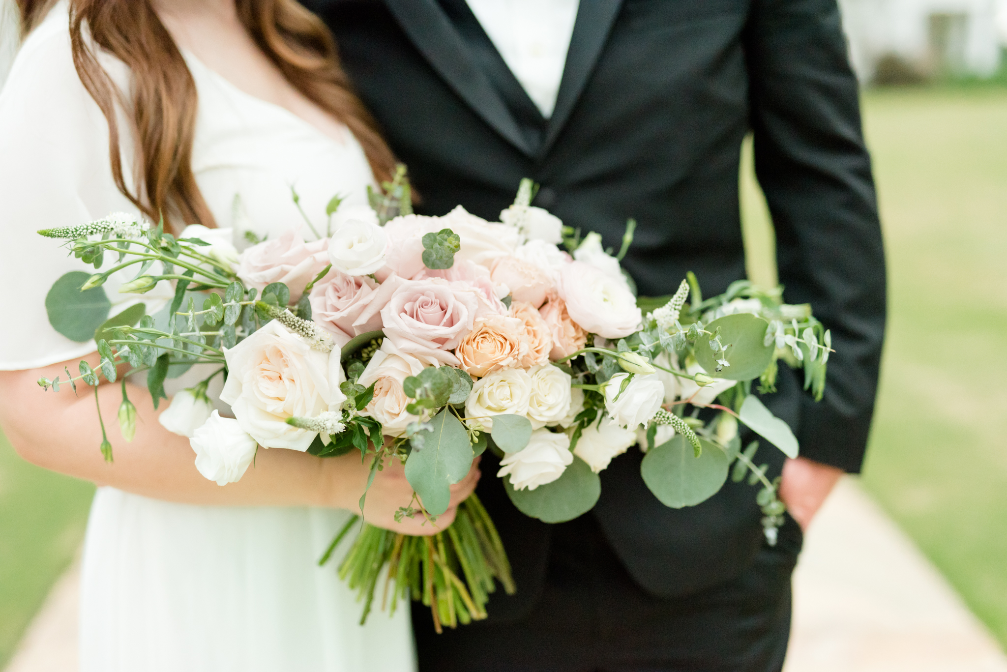 Pink and white flowers held by bride