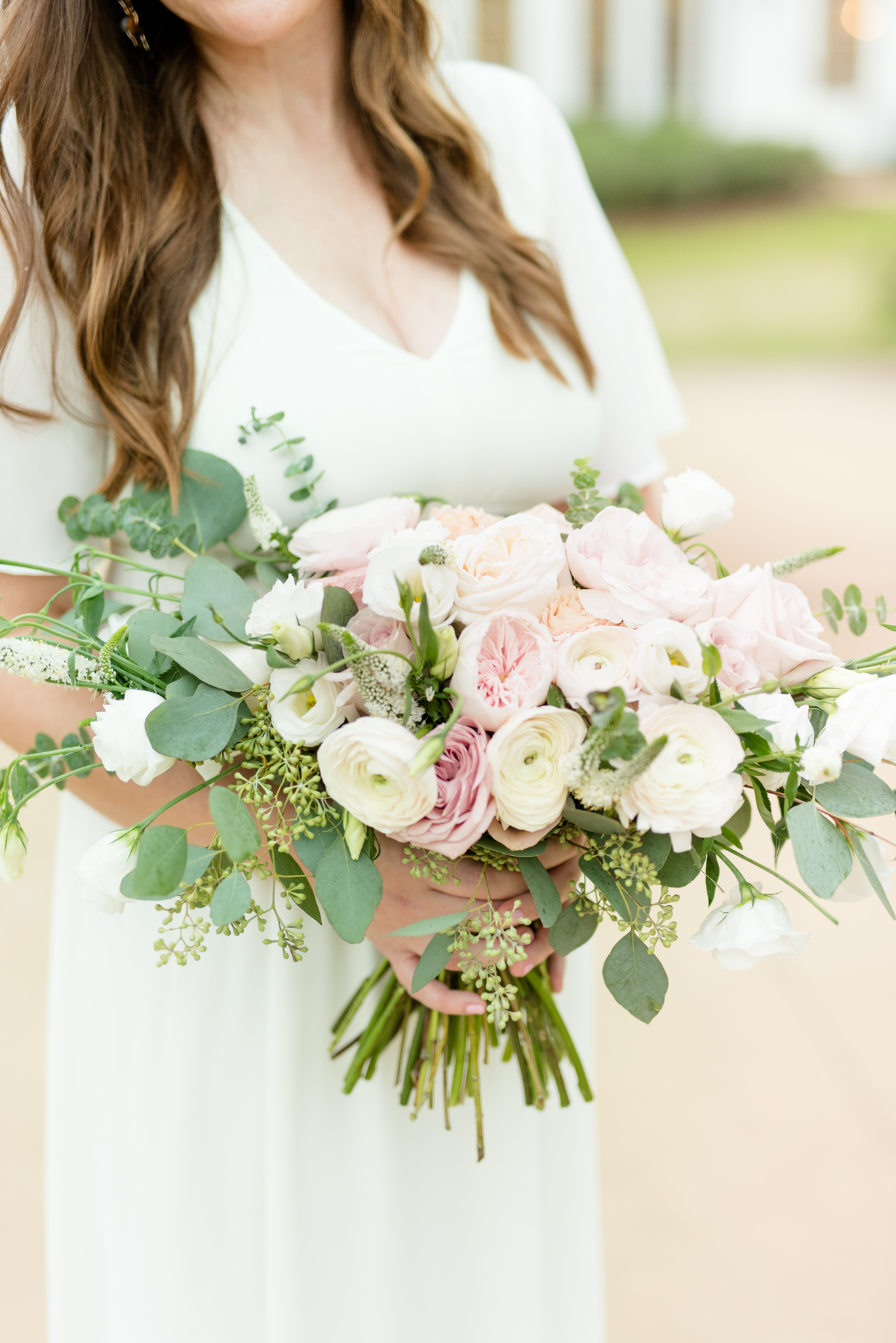 Bride holds pink and white flowers.
