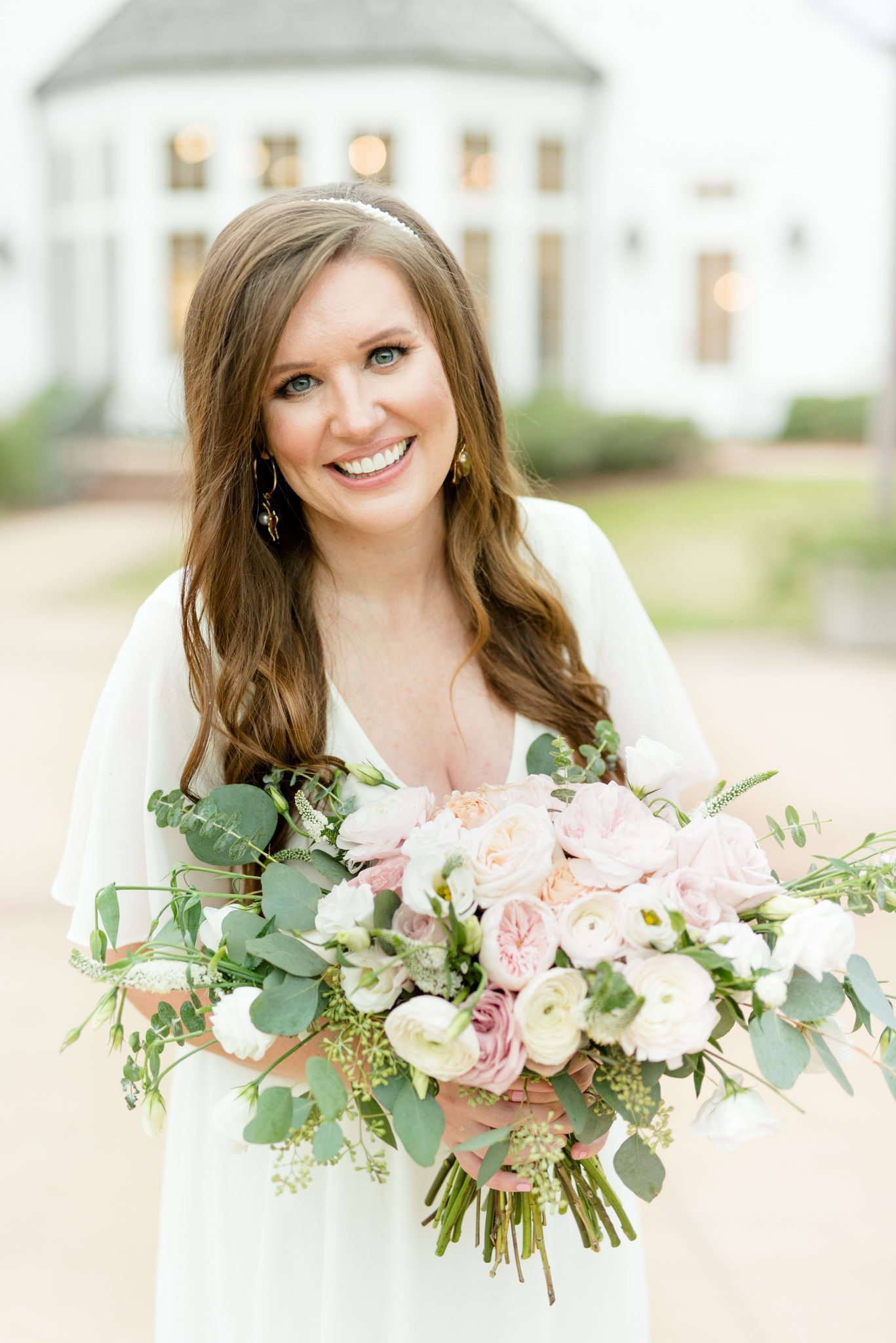 Bride smiles at camera with flowers in hand