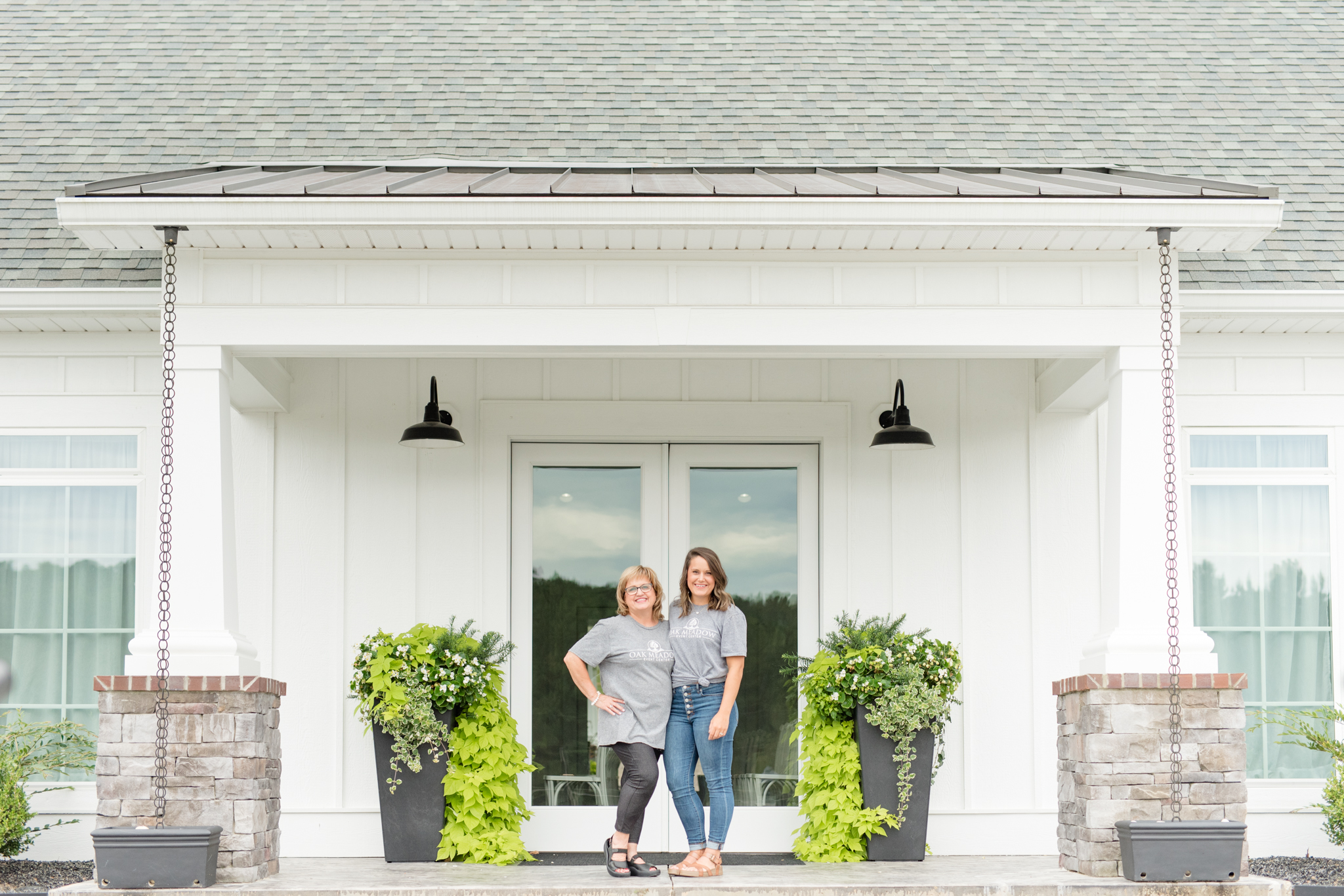 Venue owners stand on porch.