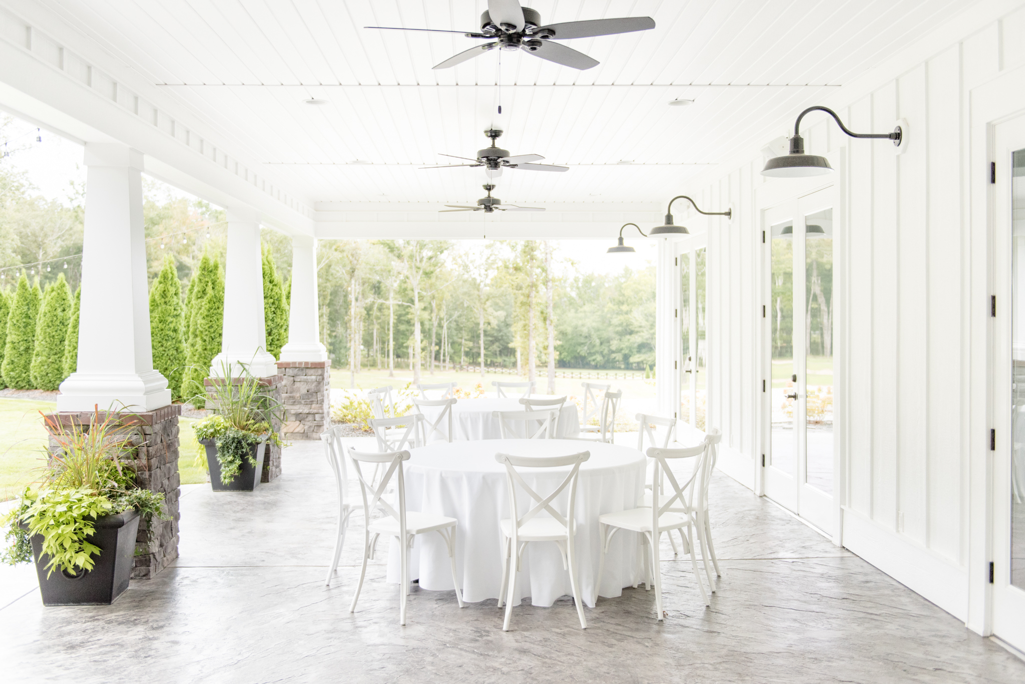 Outdoor reception space with white table and chairs.