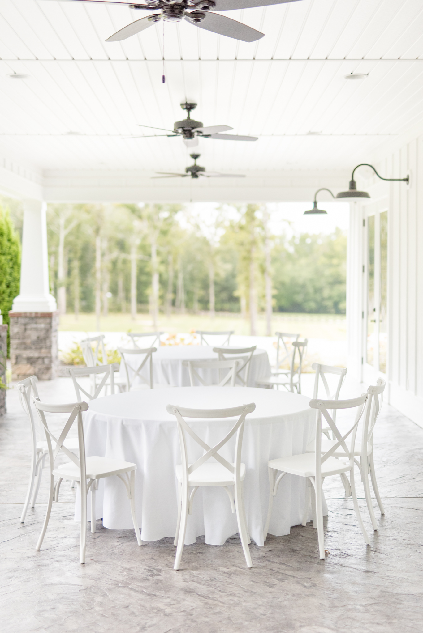 White table and chairs under awning for reception.