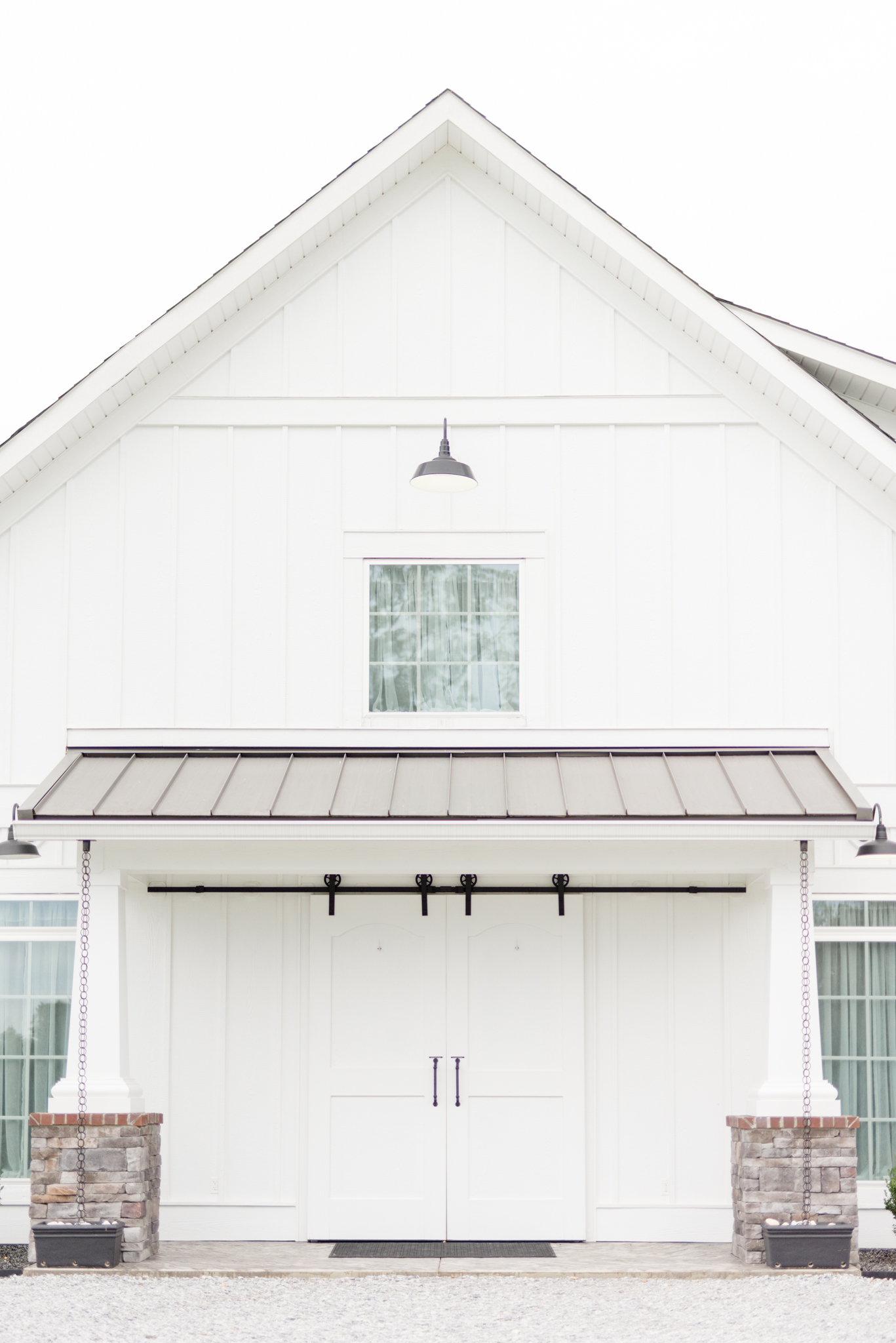 White awning and barn doors at farmhouse wedding venue.