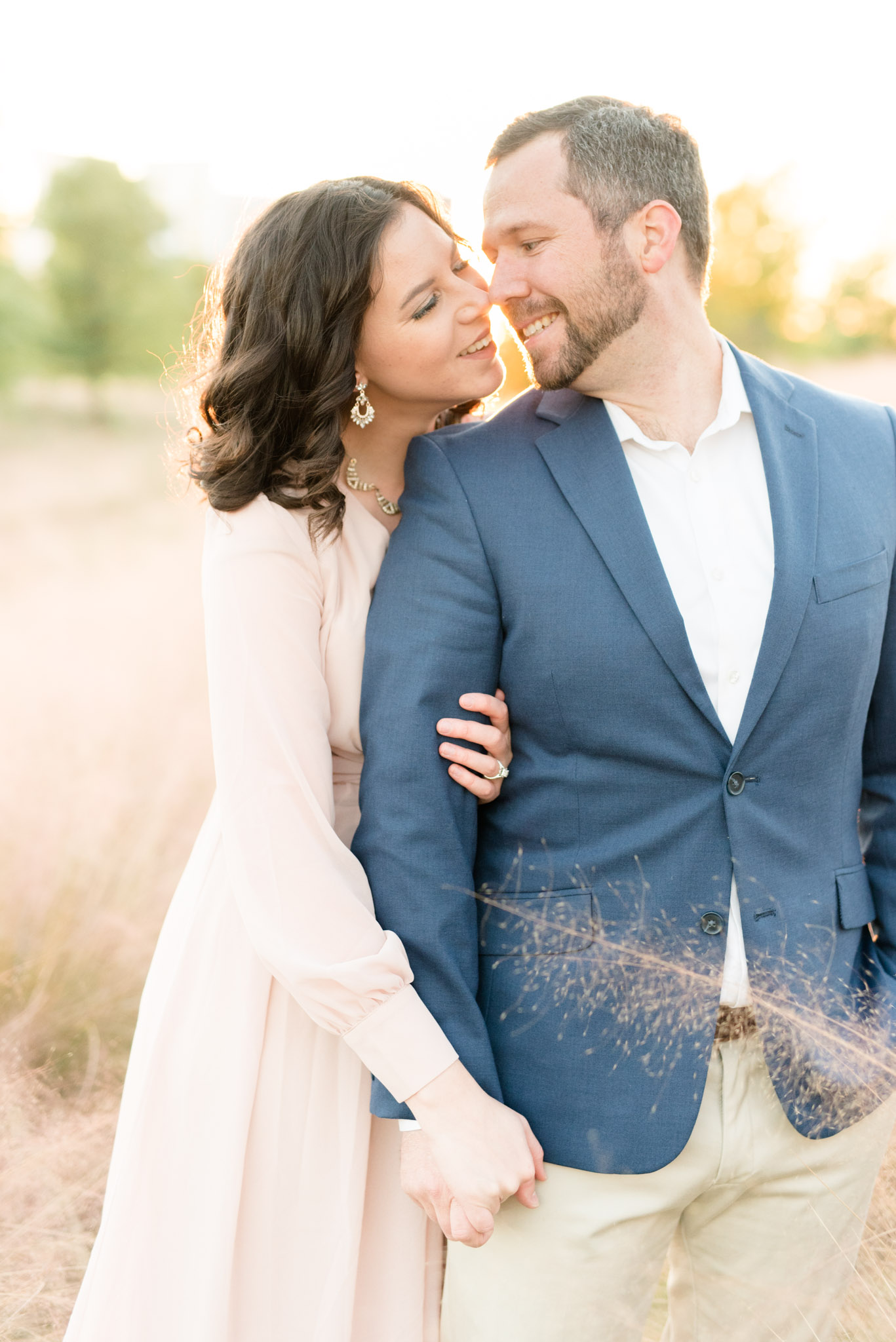 Couple laughs and leans in for kiss.