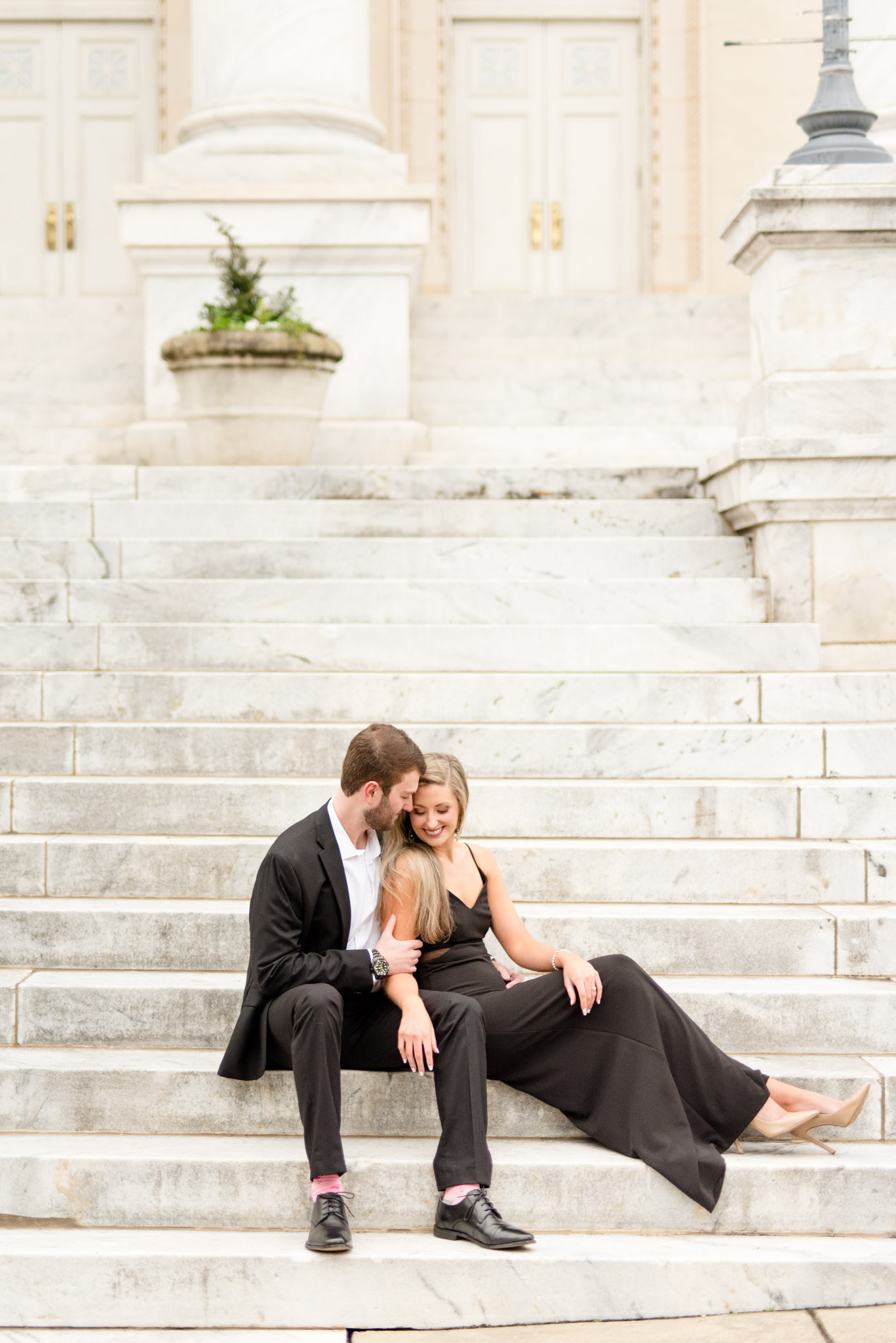 Couple snuggles on stairs.