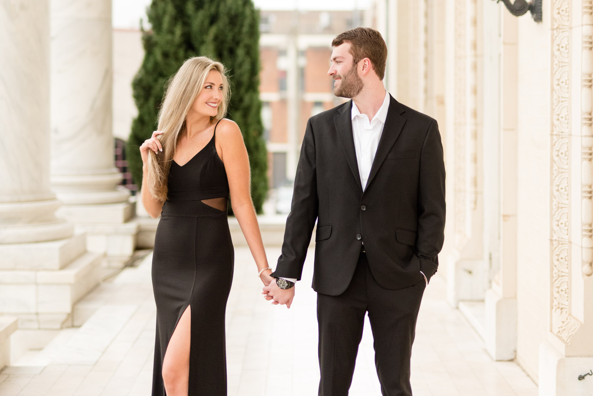 Couple looks at each other and holds hands.