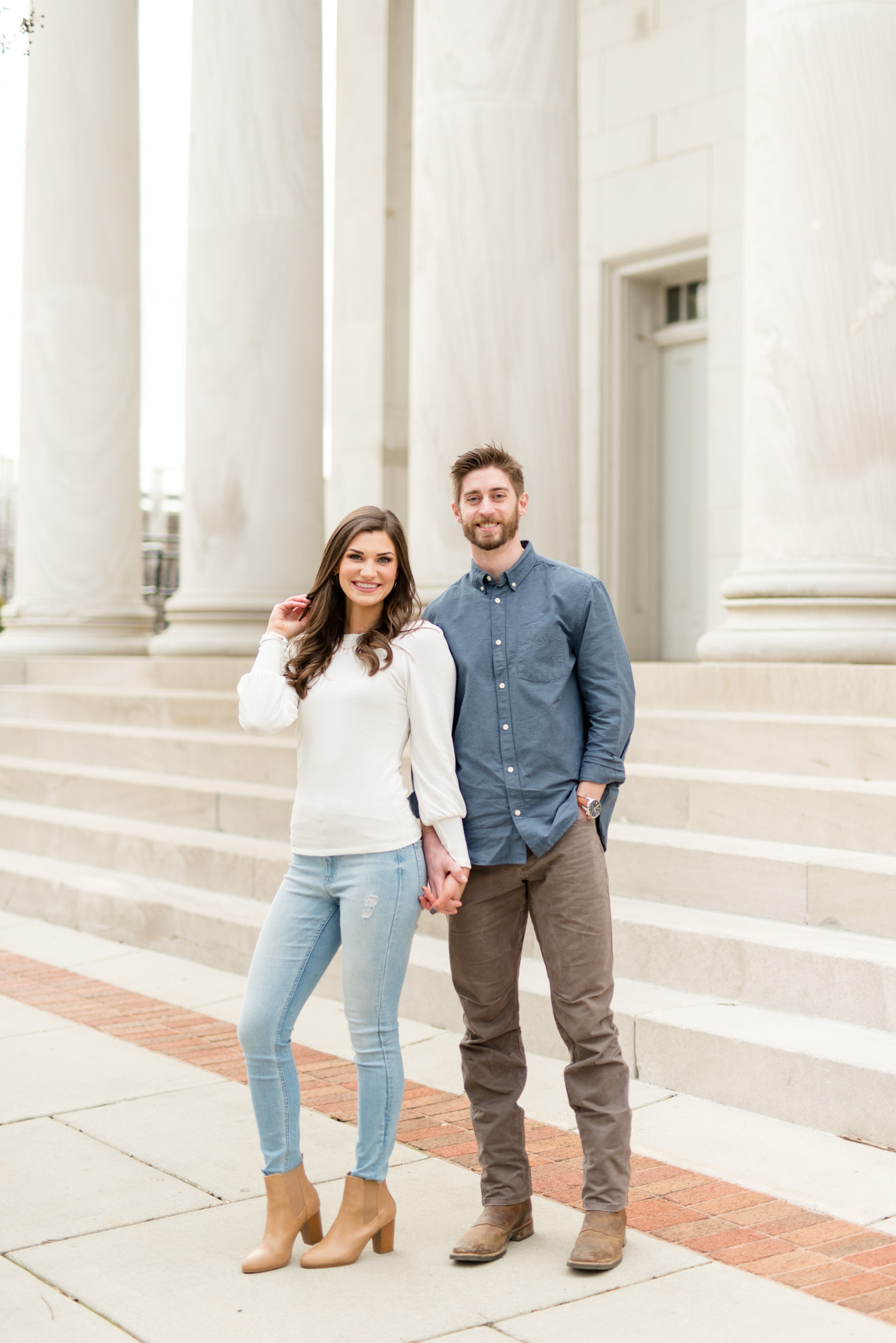 Engaged couple stands and smiles at camera.