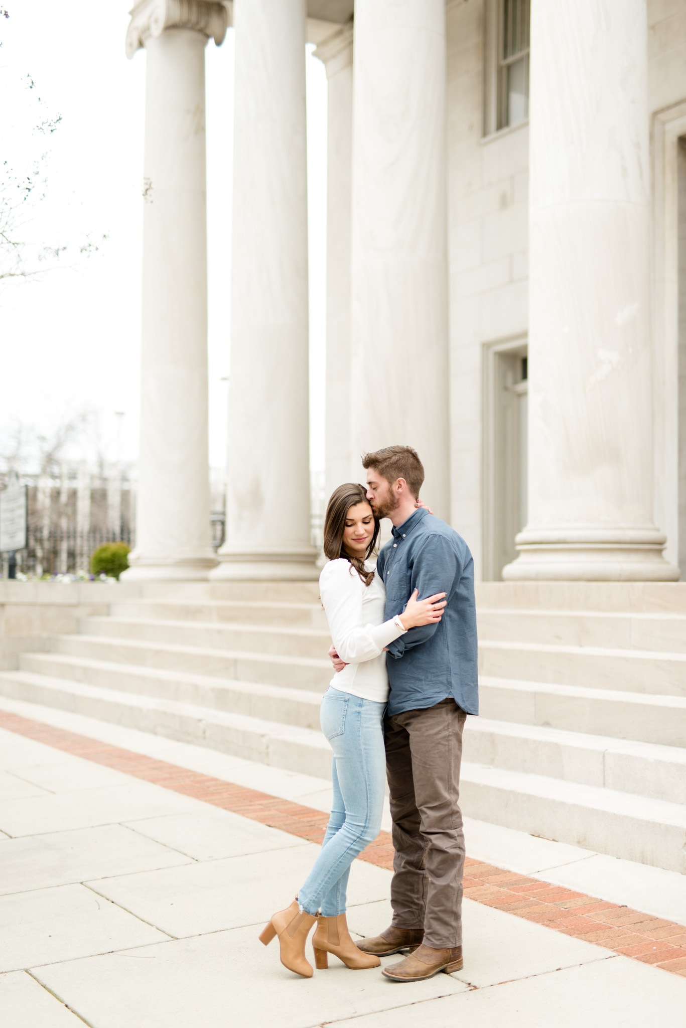 Couple snuggles near staircase in Huntsville Al.