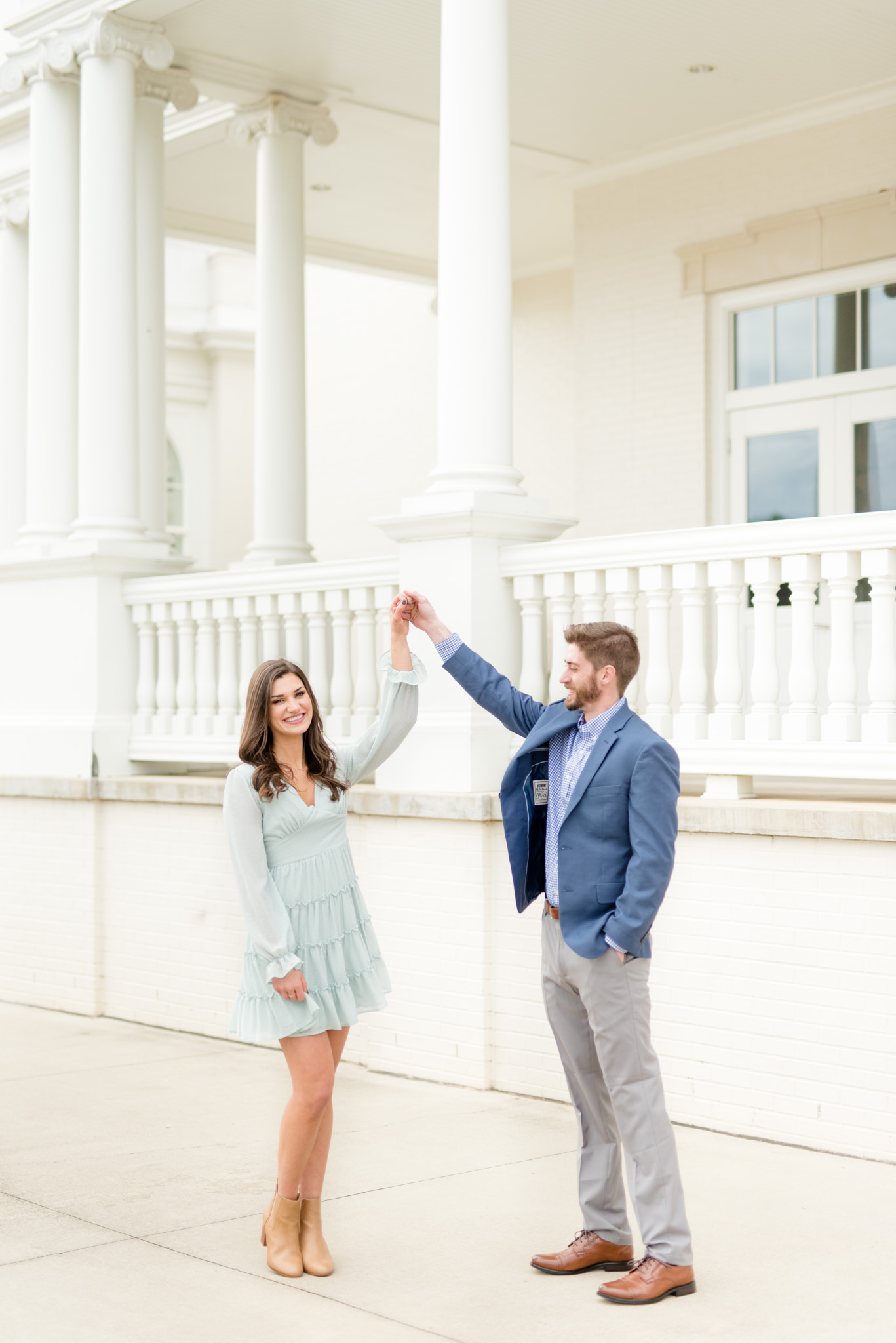 Woman looks at camera as she is twirled by fiance.