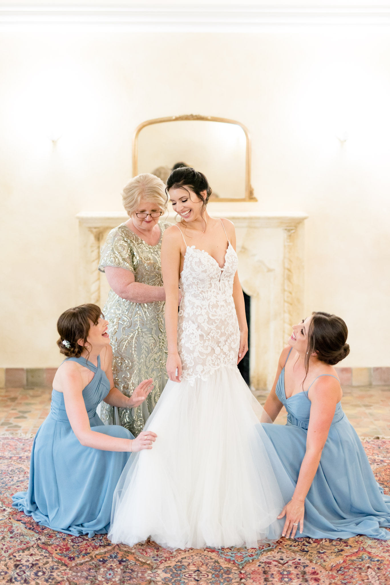 Mom and sisters help bride get ready.