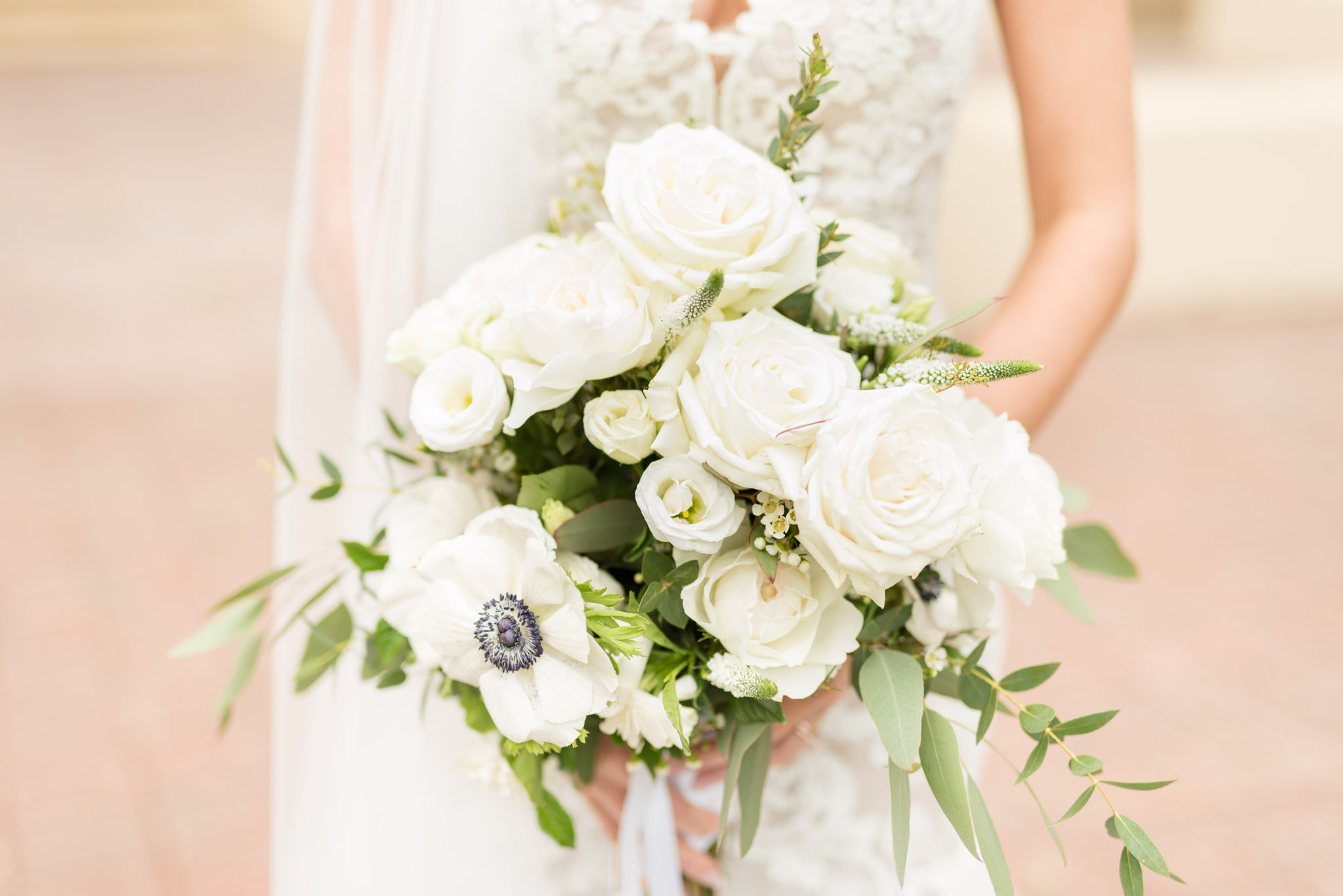 Bride holds white bouquet.