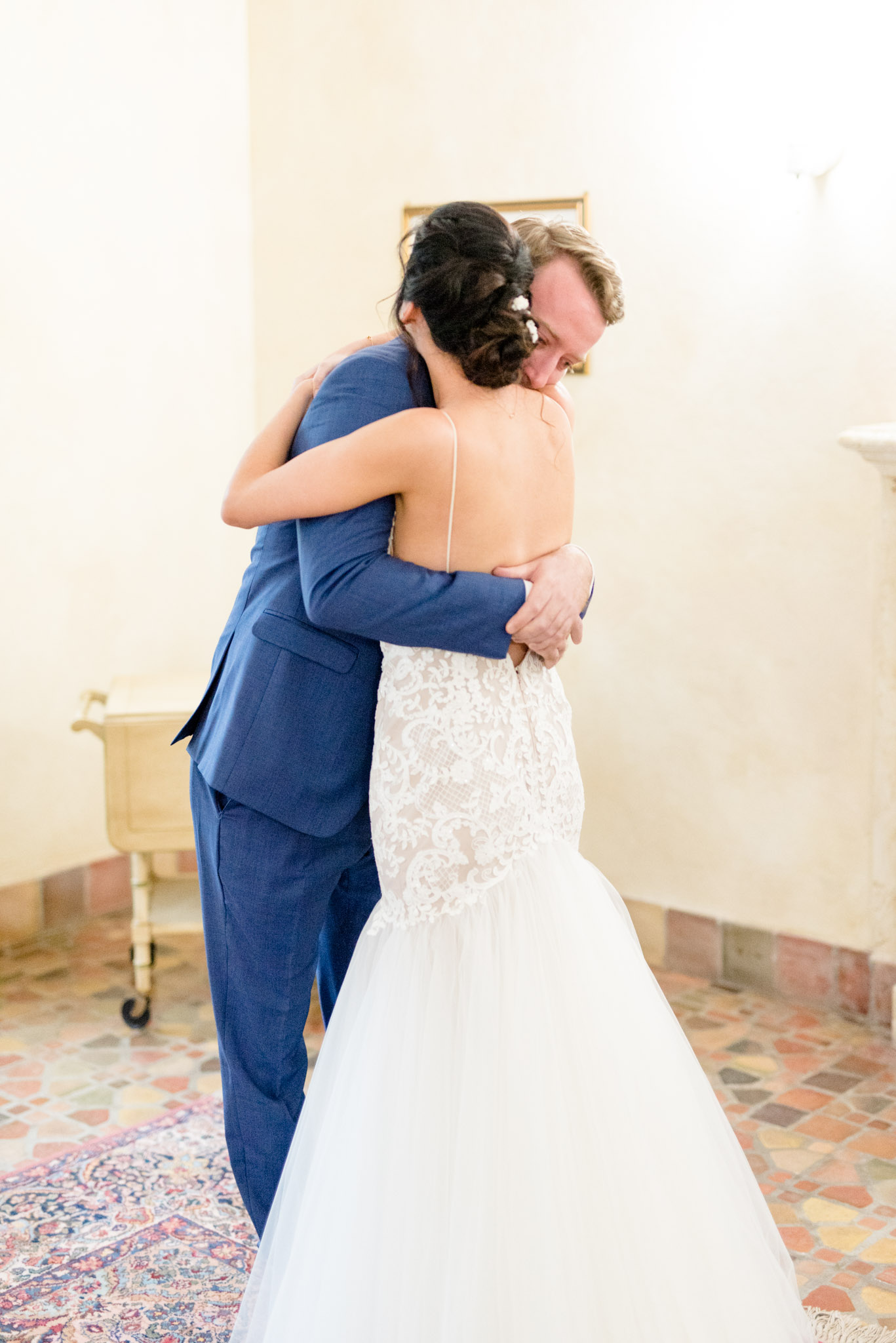 Groom hugs bride during first look.