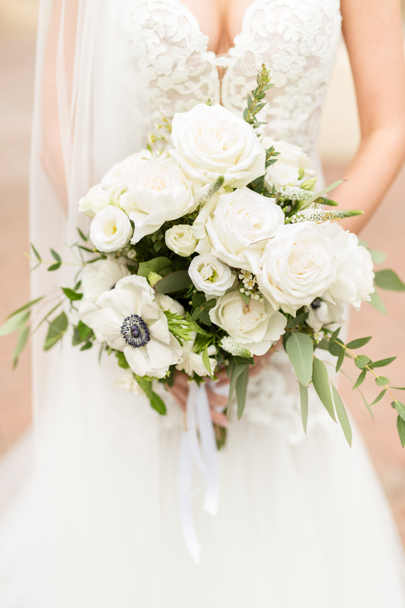 Bride holds white flowers.