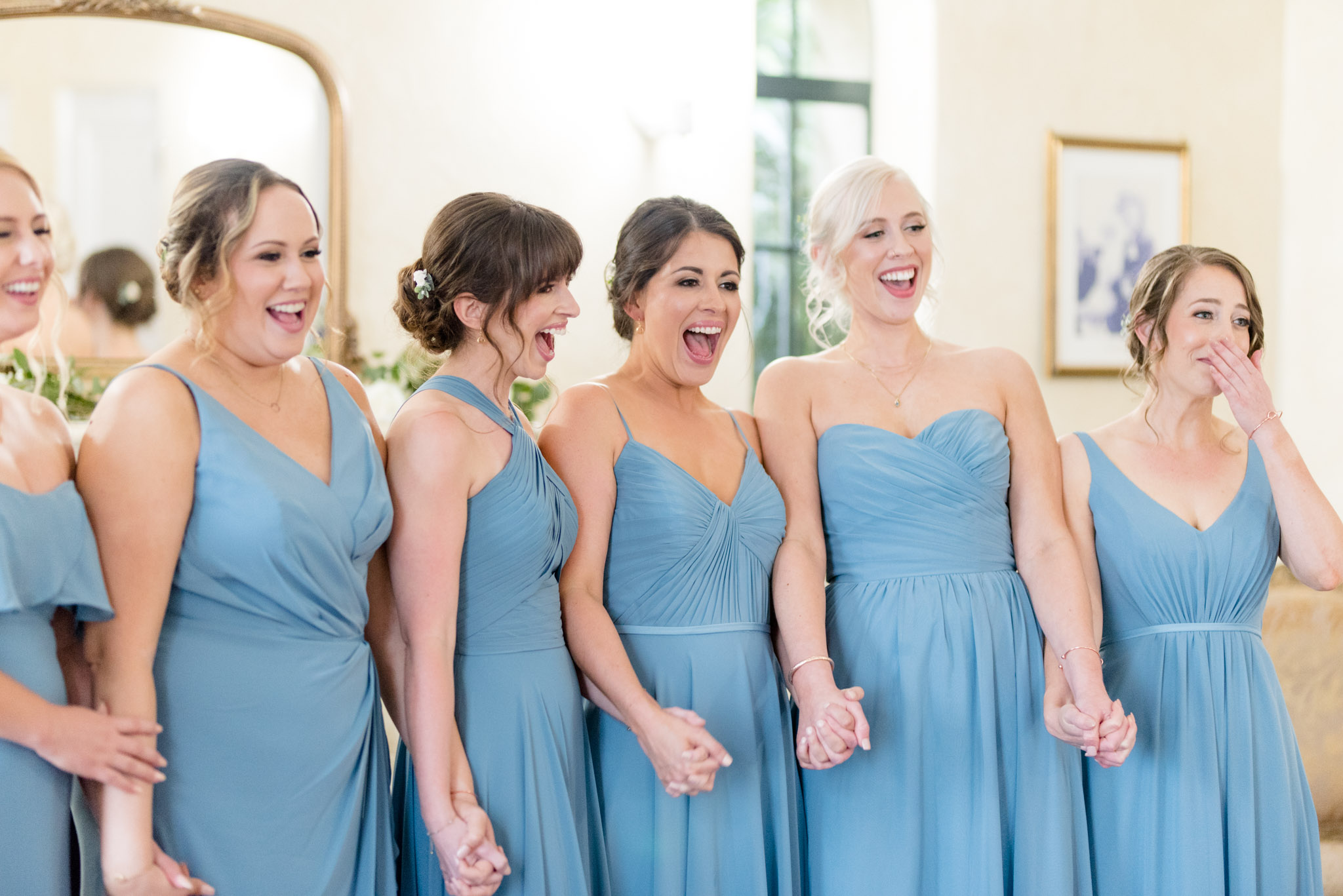 Bridesmaids smile as they see bride.