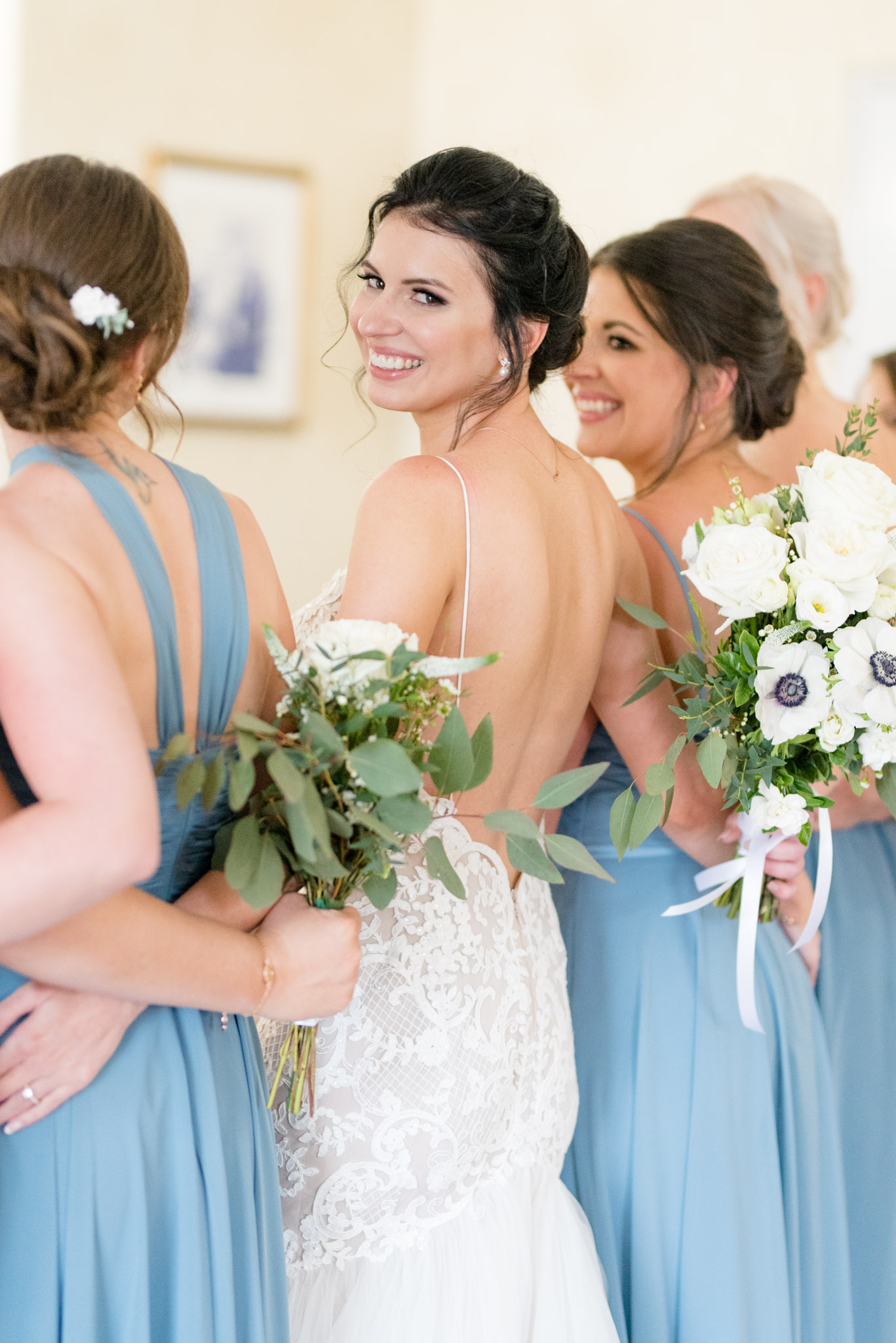 Bride looks over shoulder and smiles.