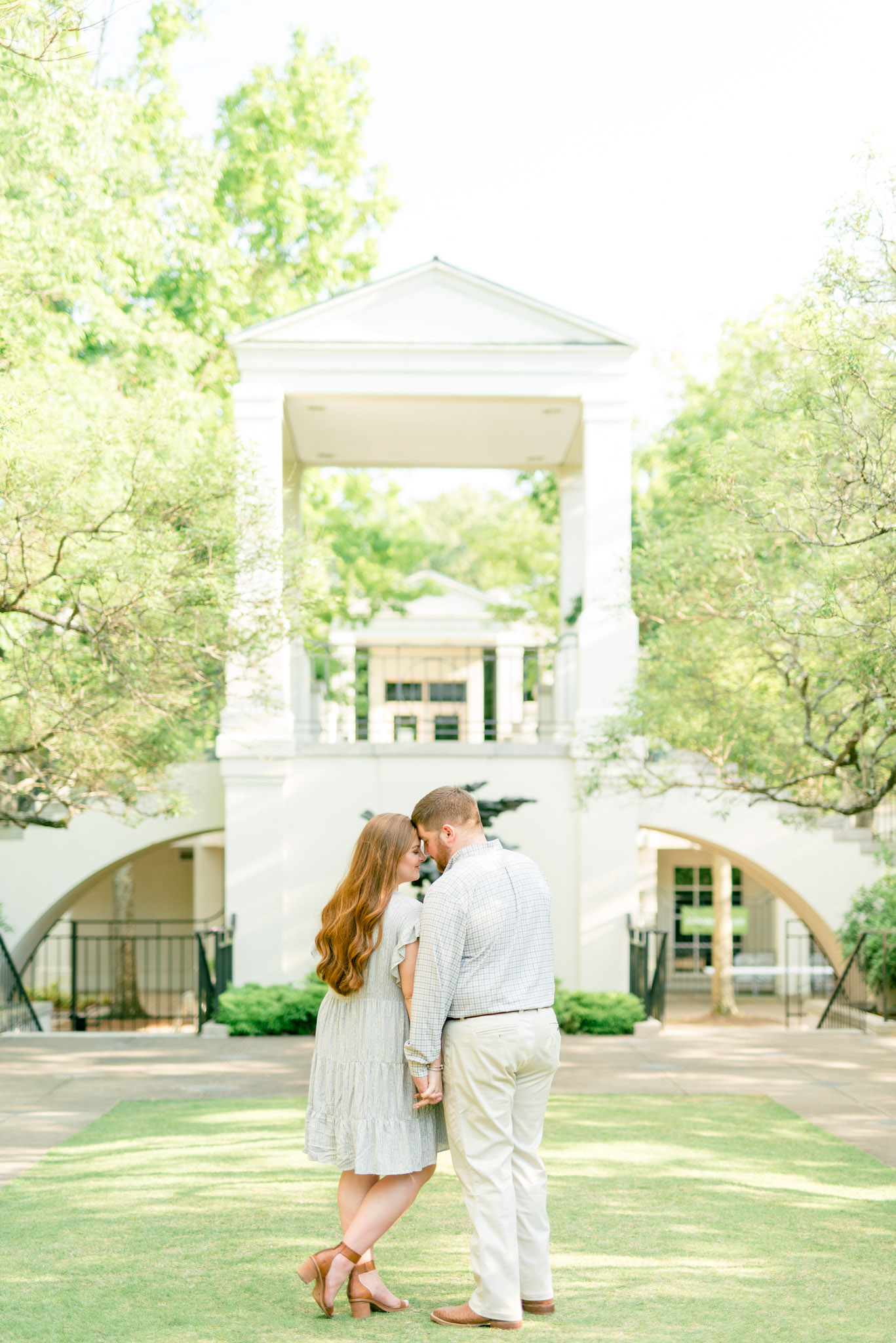 Man and woman snuggle in gardens.