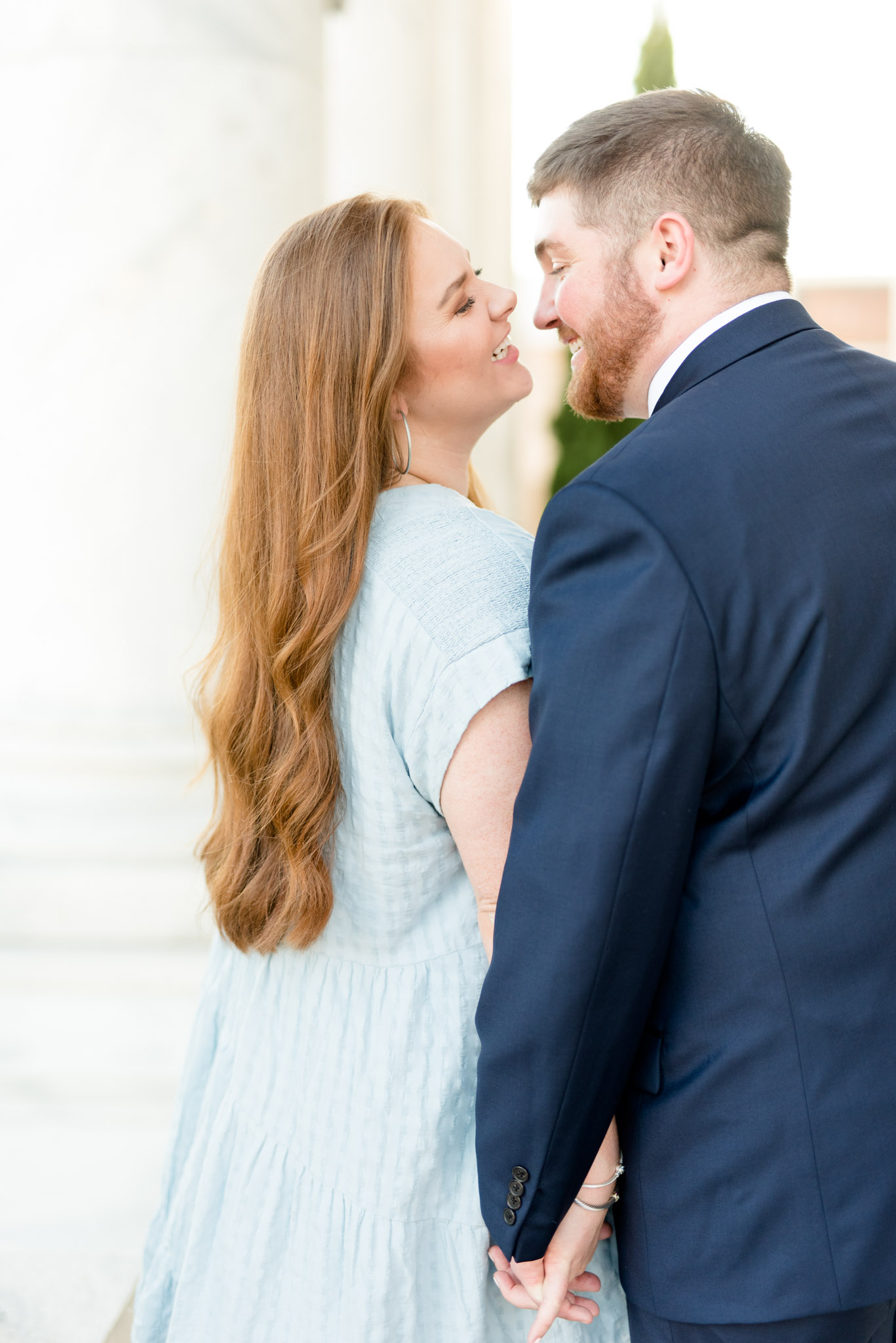 Couple laughs as they go in for a kiss.