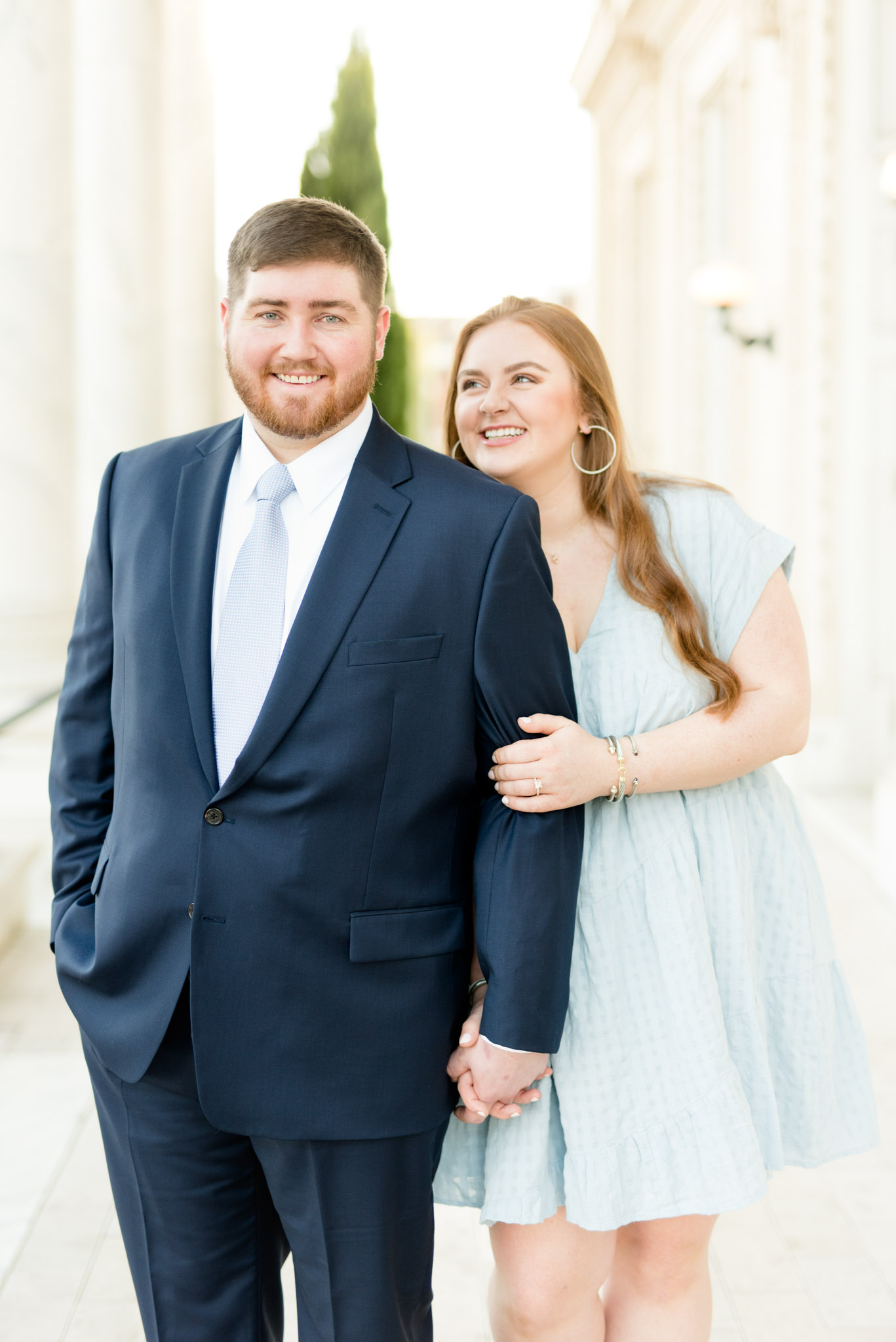 Man looks at camera while fiance looks at him.