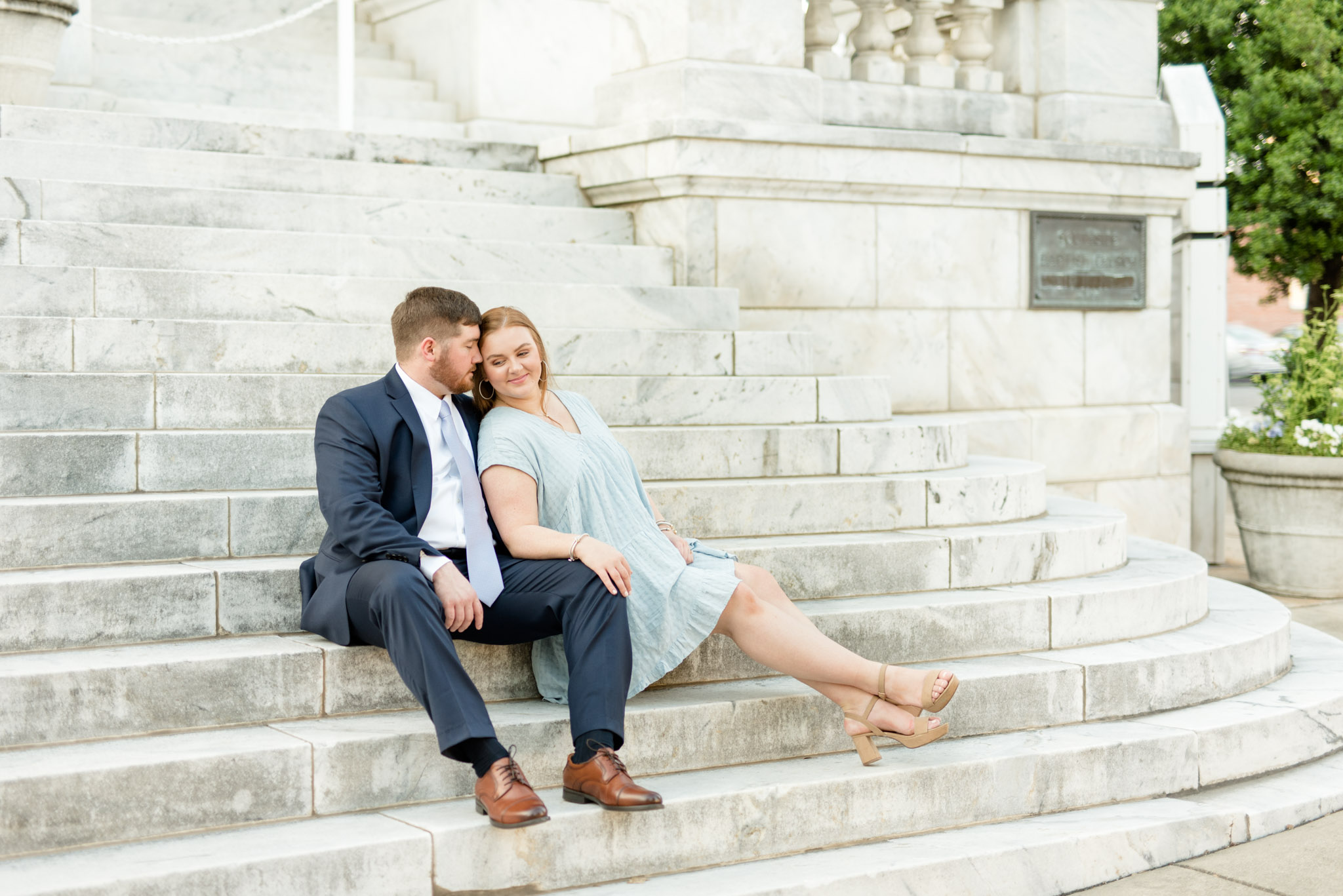 Couple cuddles on staircase.