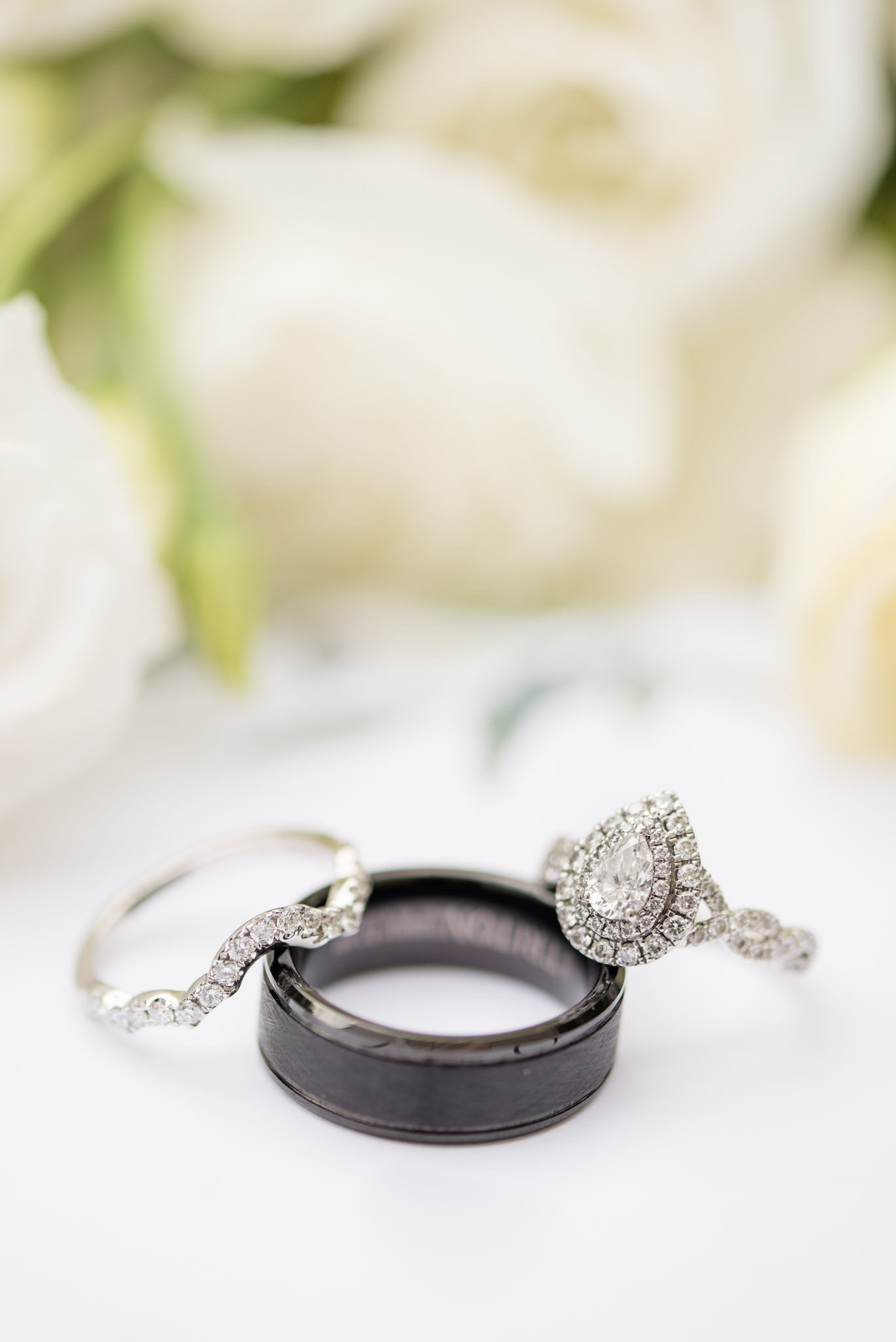 Wedding rings sit in front of flowers.