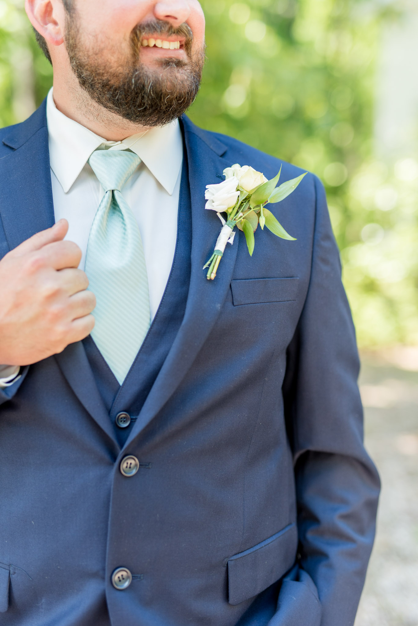 Groom's boutonniere pinned to jacket.