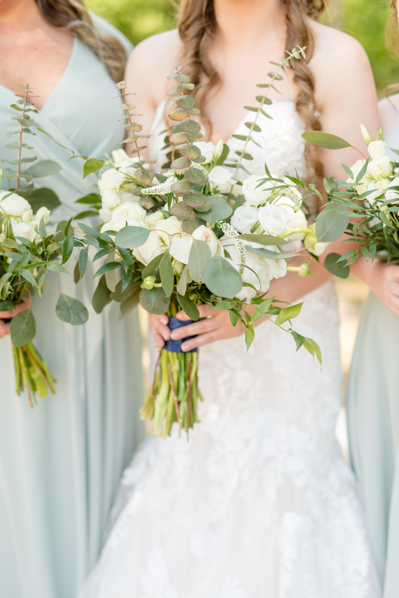 Bride holds white flowers.